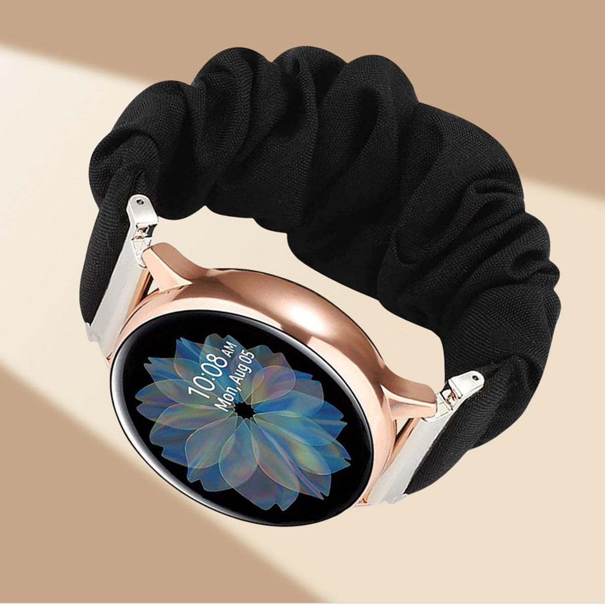 Smartwatch oro rosa con cinturino a scrunchie nero. Il quadrante mostra ora e data.