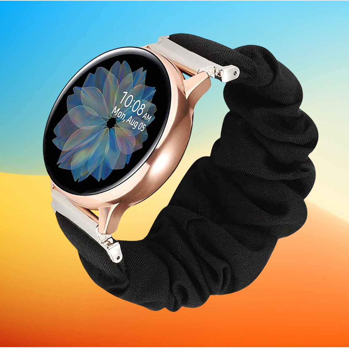 Smartwatch oro rosa con cinturino a scrunchie nero, su uno sfondo con gradienti giallo e arancione.