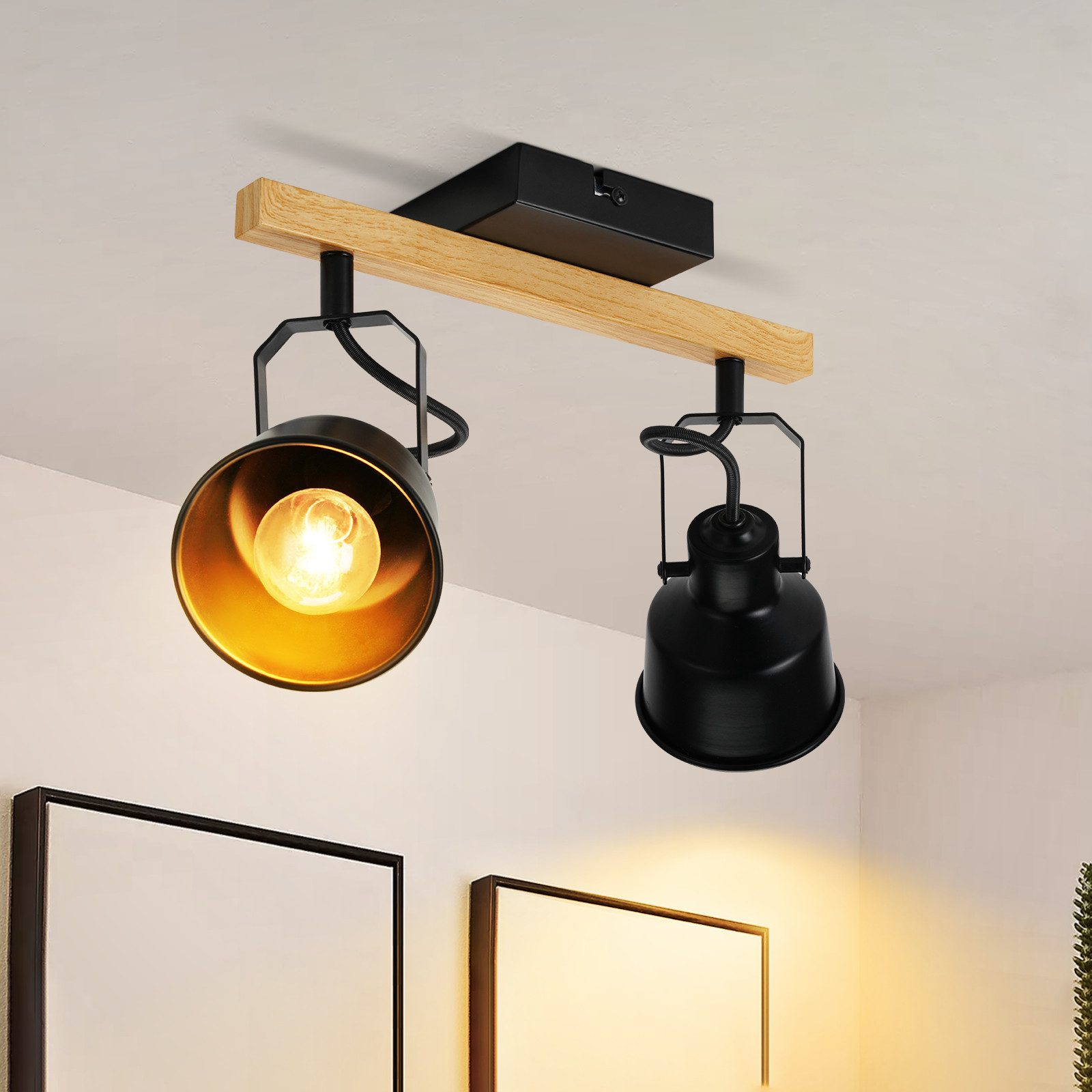 Lampada da soffitto con due faretti neri su una trave di legno, su sfondo bianco.