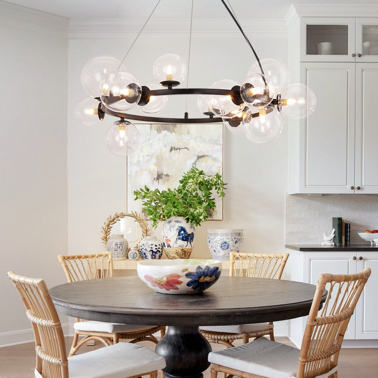 Sala da pranzo con tavolo rotondo in legno, sedie in rattan e lampadario con sfere di vetro.
