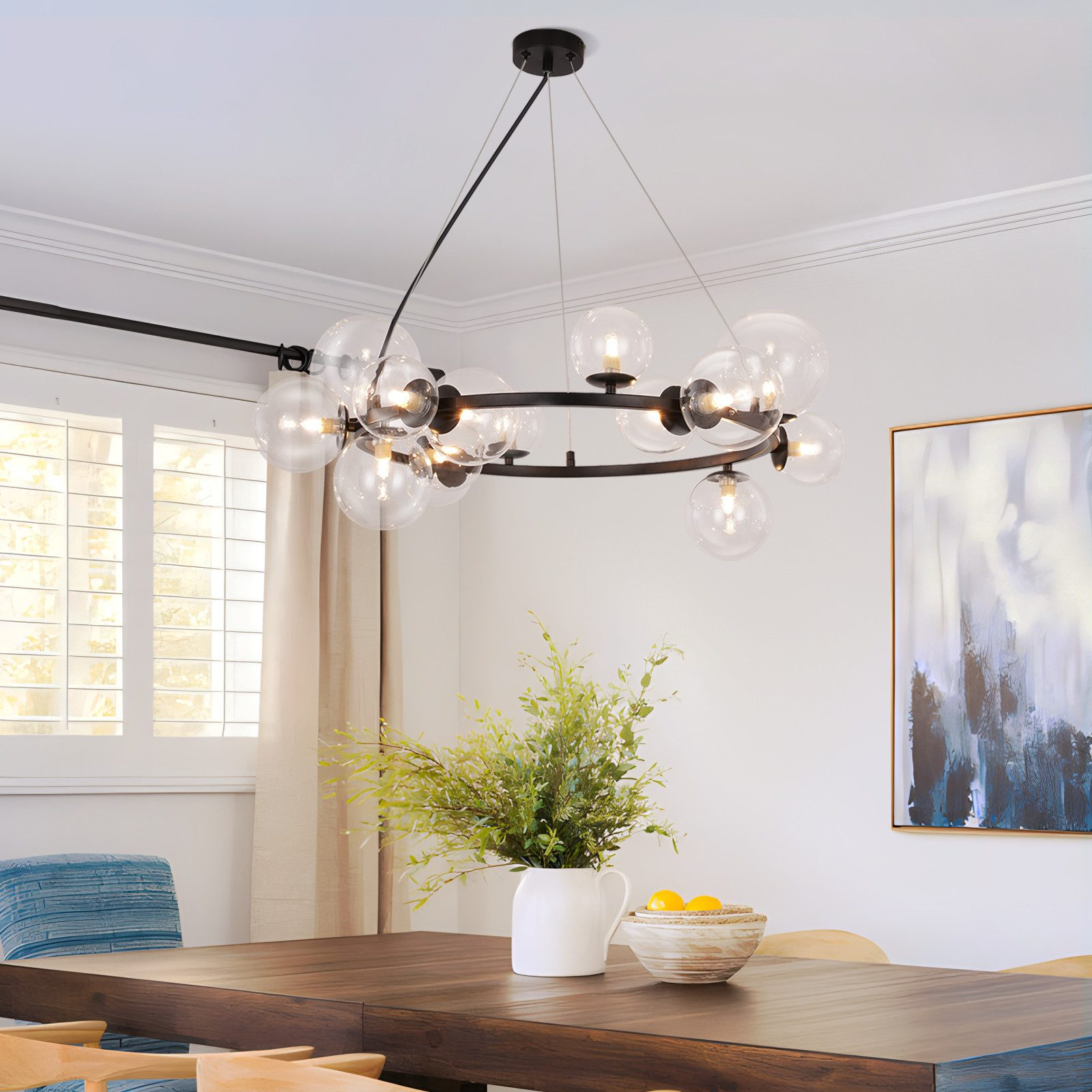Sala da pranzo con tavolo in legno scuro, sedie blu e lampadario con sfere di vetro.