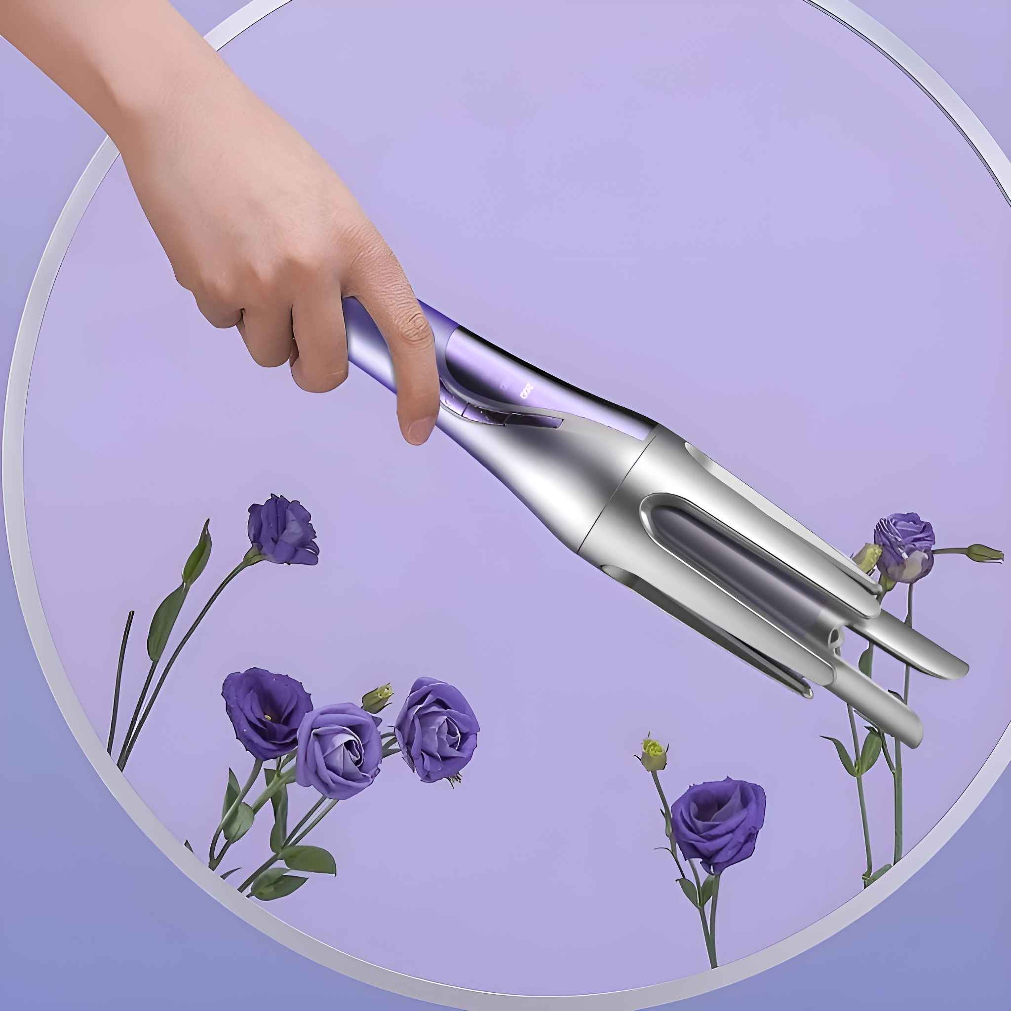 Eine Hand, die einen lila-silbernen Lockenstab hält, umgeben von lila Blumen.