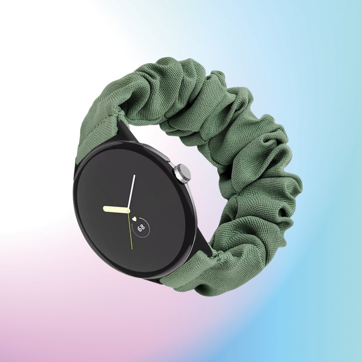 Uno smartwatch nero con un cinturino a scrunchie in tessuto verde su uno sfondo blu e rosa.