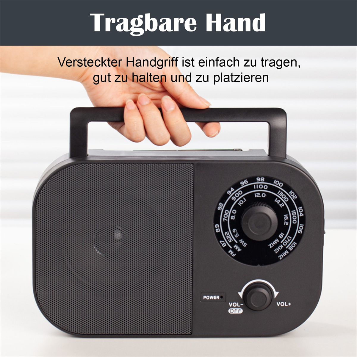 Ein schwarzes tragbares Radio, das von einer Hand gehalten wird und seinen versteckten Griff zum einfachen Tragen zeigt.