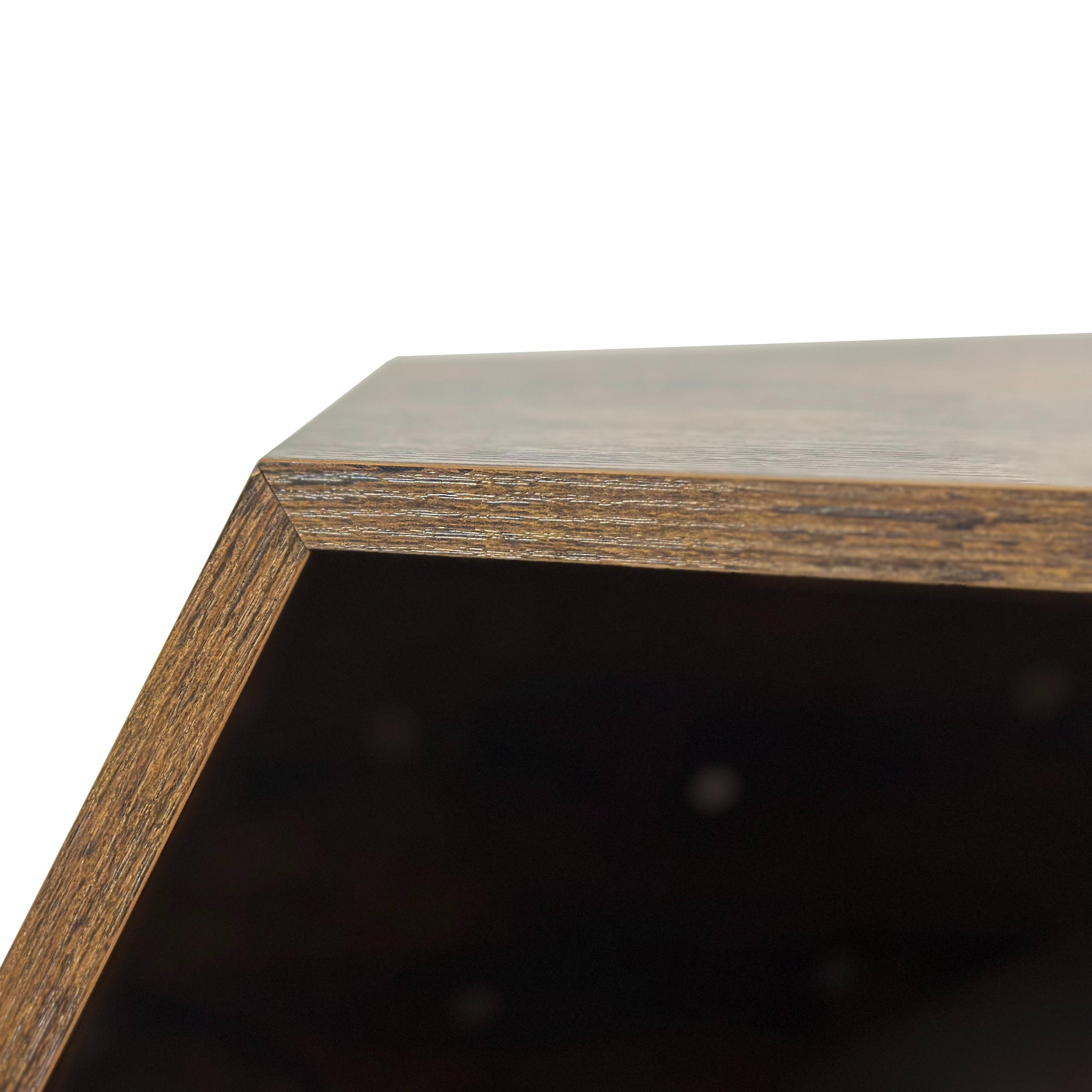 Nahaufnahme einer Ecke einer braunen Holzkiste, die sich auf die Kante und das dunkle Innere mit kleinen weißen Punkten konzentriert.