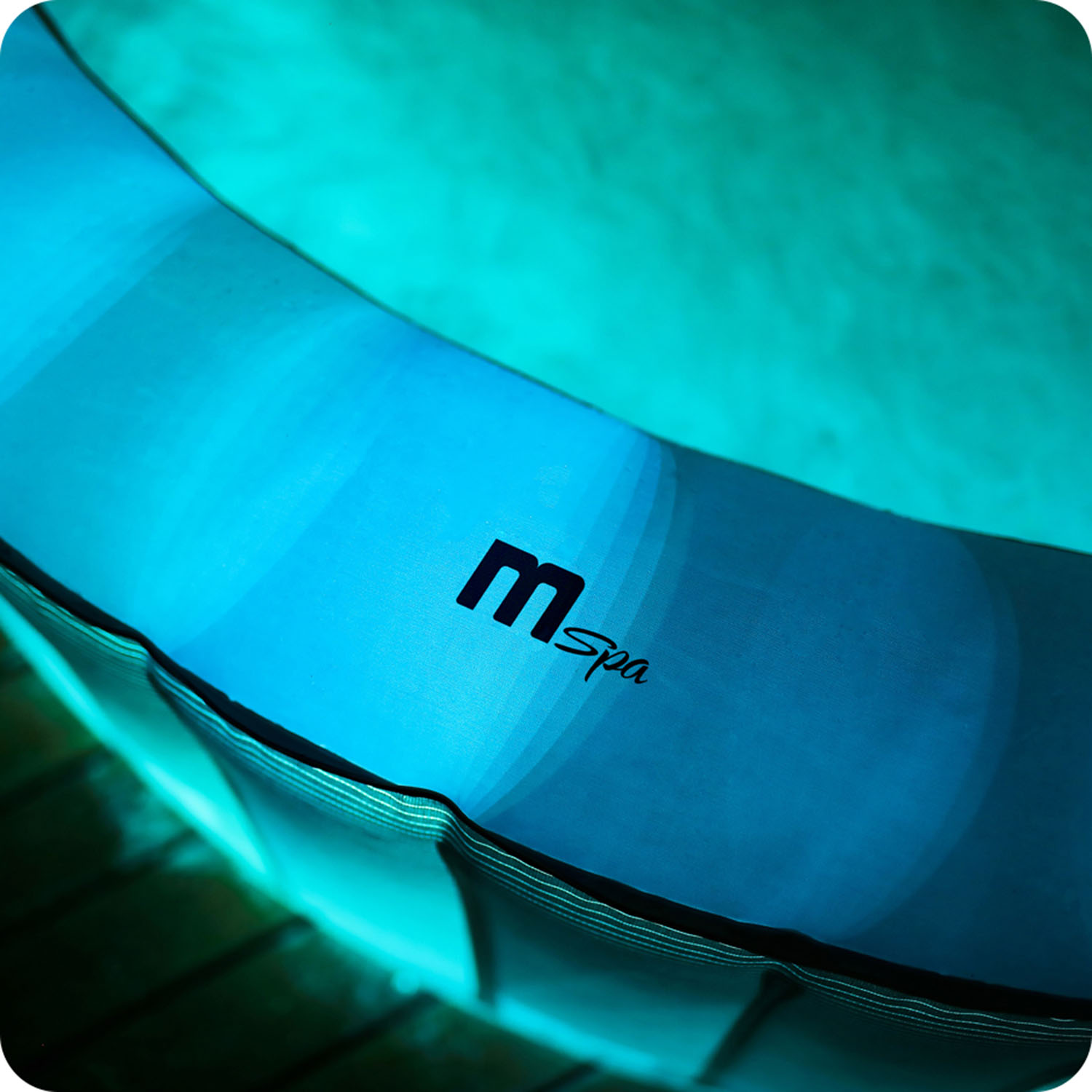 Zbliżenie na bok niebieskiej nadmuchiwanej wanny z hydromasażem z logo „MSpa”.
