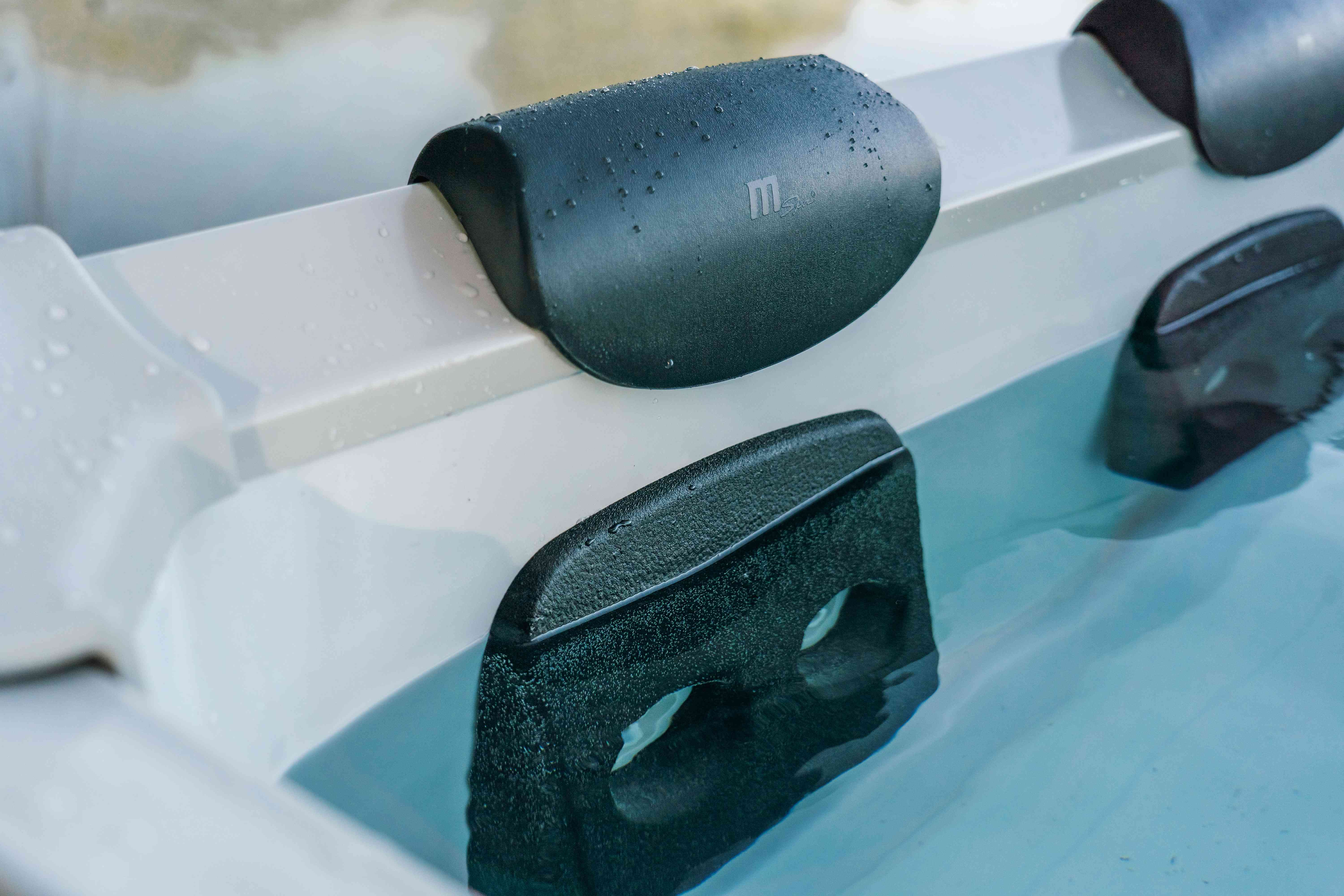 Zbliżenie wanny z hydromasażem z szarymi zagłówkami i czystą wodą.