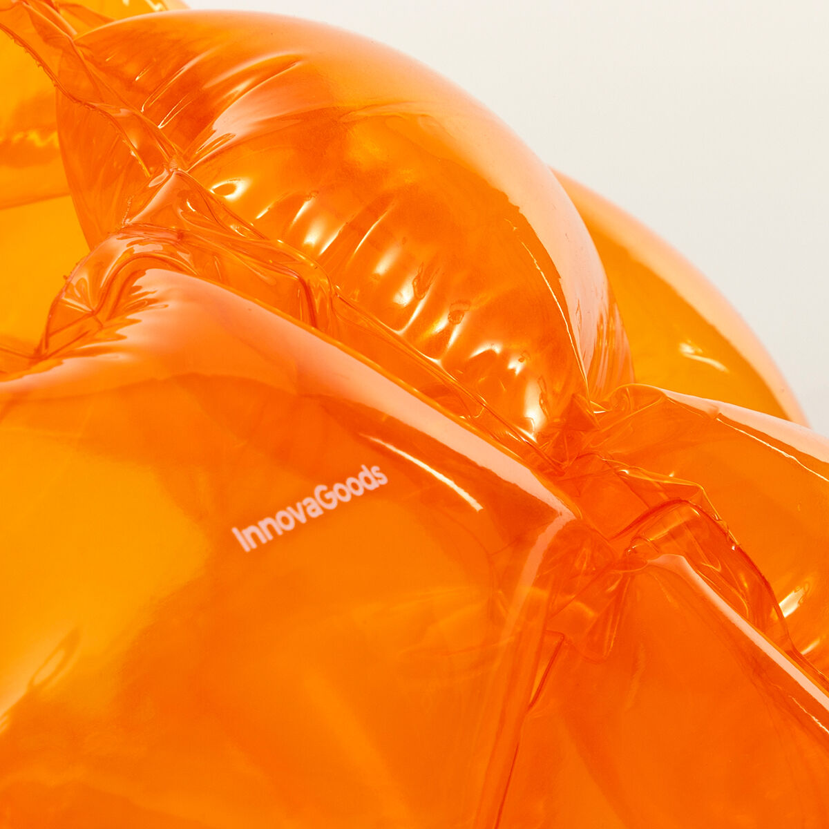 Primer plano de un inflable naranja con el logotipo de InnovaGoods, destacando su textura y material.
