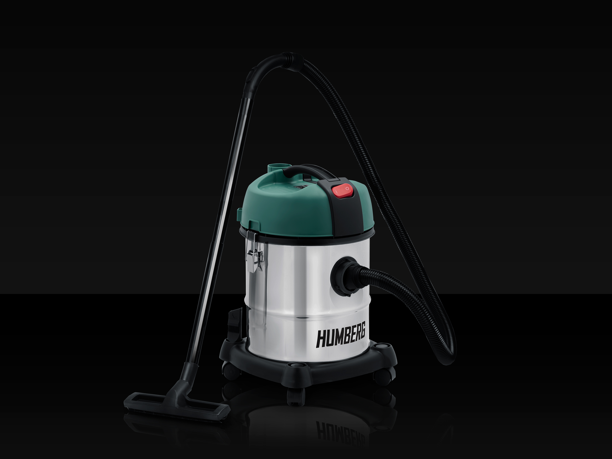 Srebrno-zielony odkurzacz do pracy na sucho i mokro z czarnym wężem i nasadkami na czarnej, odblaskowej powierzchni.