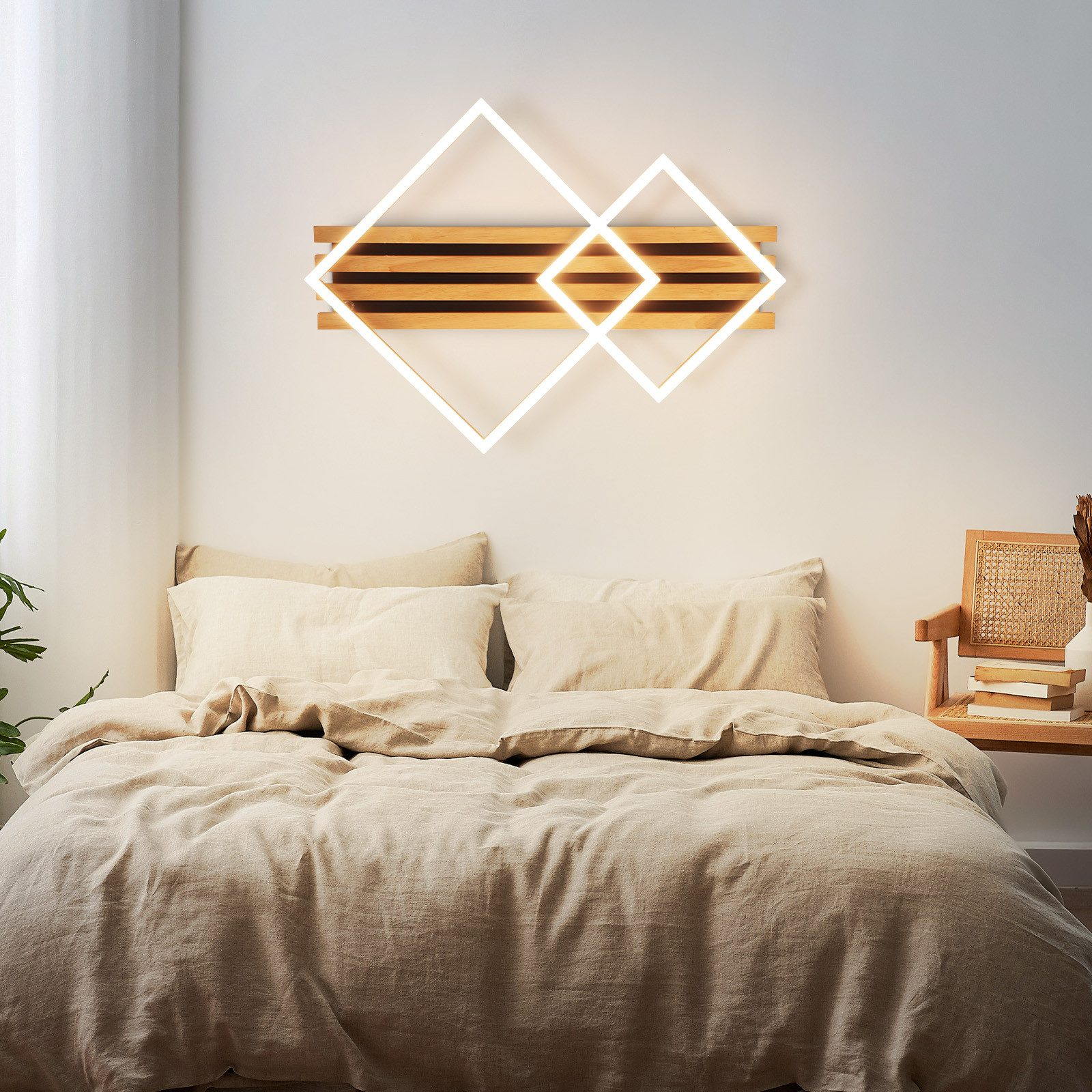 Scena di camera da letto con un letto e un comodino. Sopra il letto è montata una lampada da parete in legno con cornici quadrate.