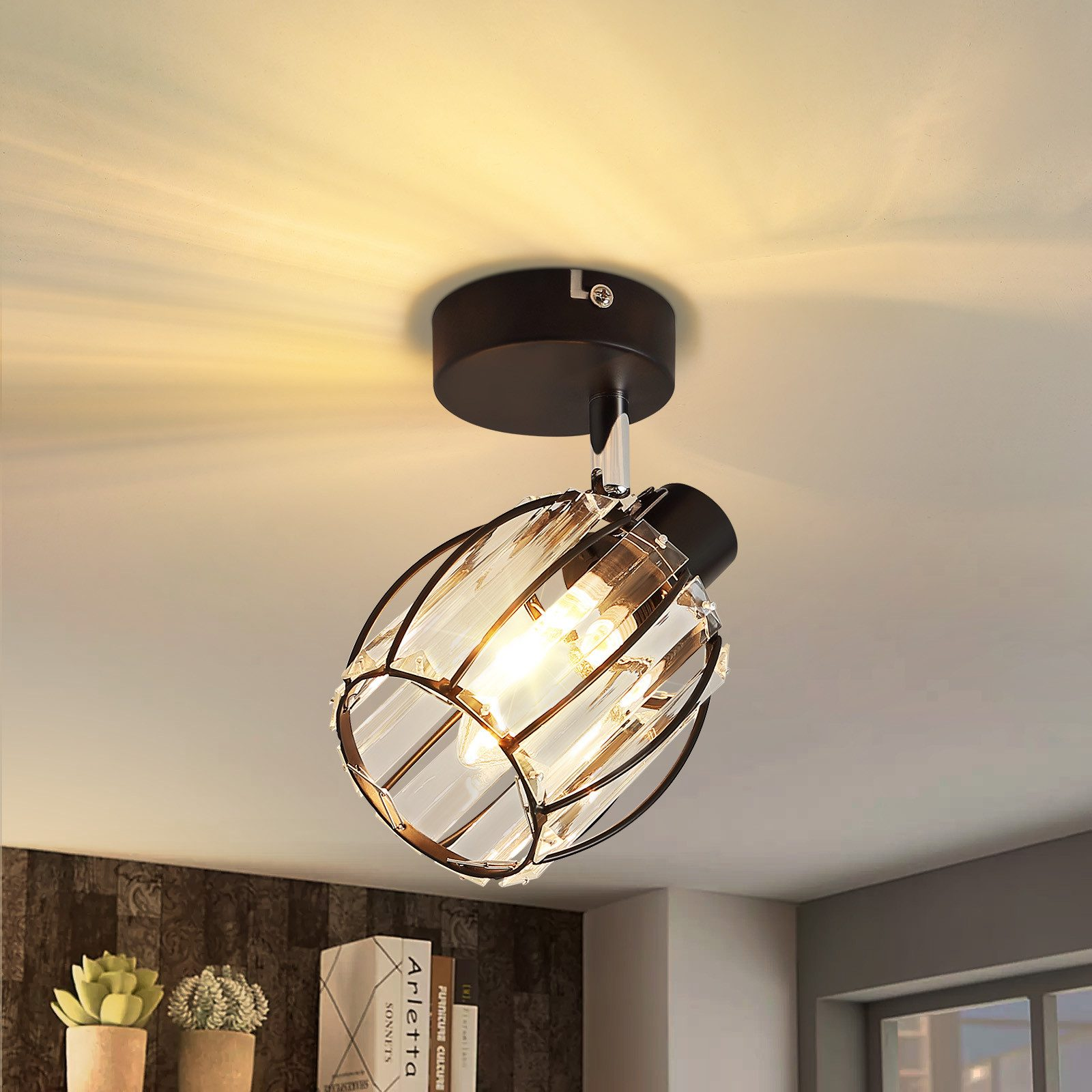 Una plafoniera con base nera e design a gabbia di cristallo è montata su un soffitto bianco.