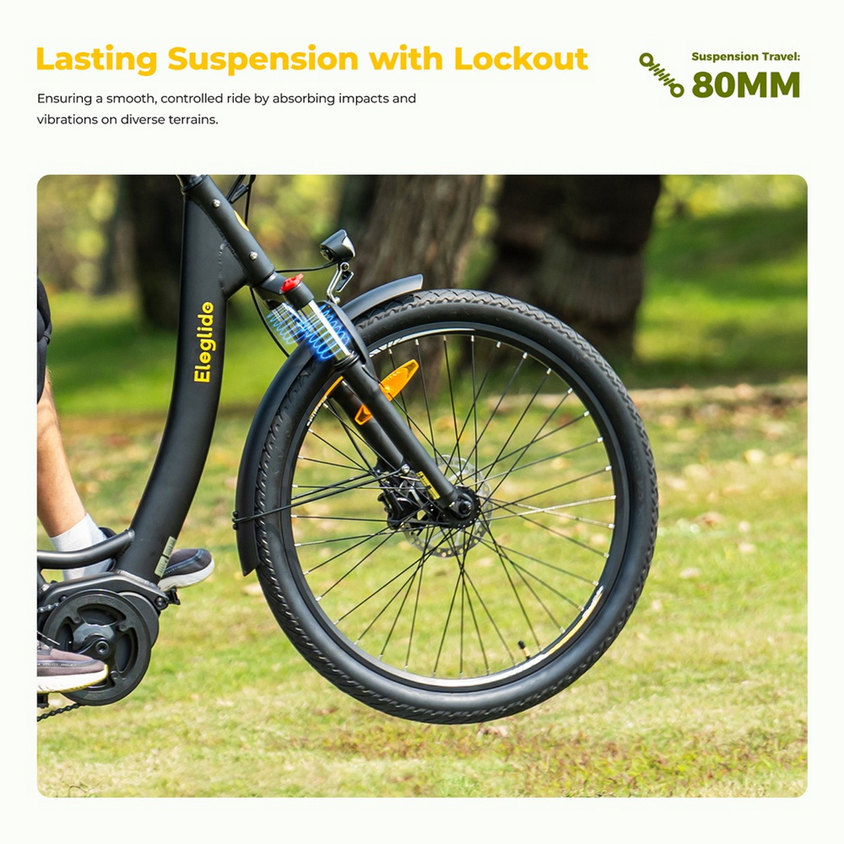 Nahaufnahme des Vorderrads eines schwarzen E-Bikes. Die Federung ist sichtbar. Gras ist im Hintergrund.