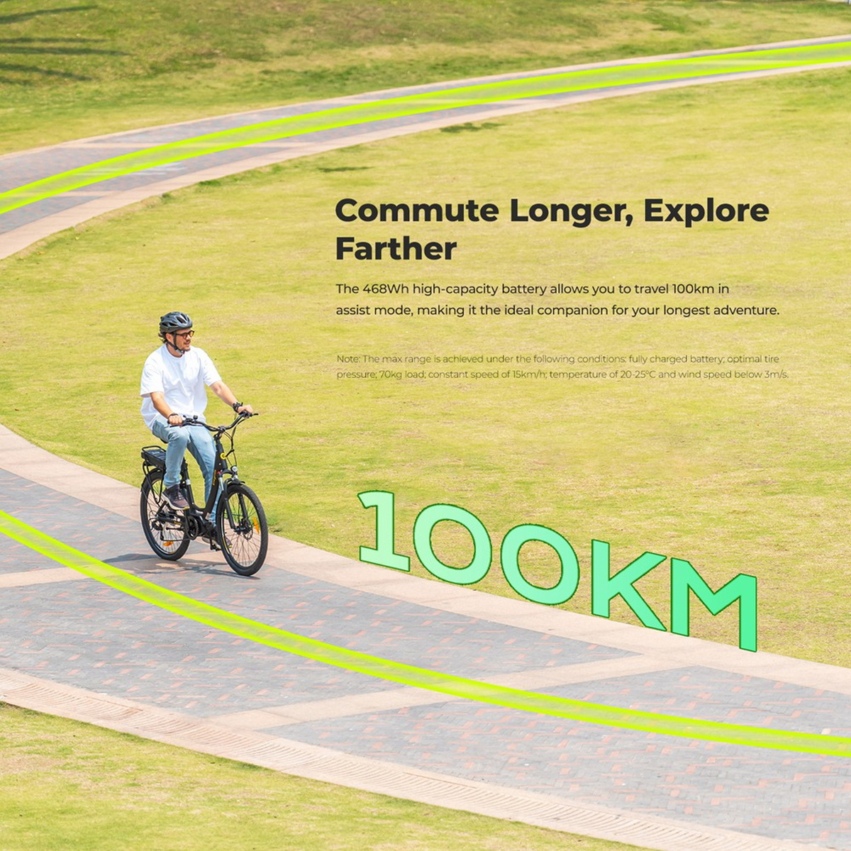 Osoba jedzie rowerem elektrycznym ścieżką przez zielone pole, z tekstem „100KM” w tle.