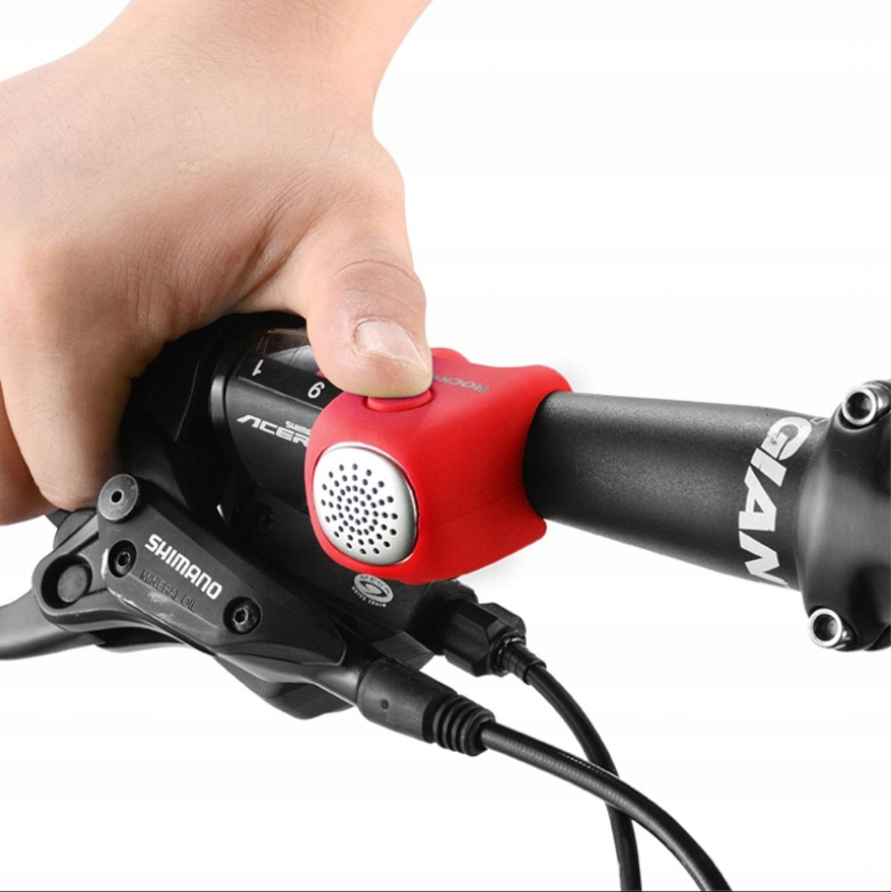 Ręka naciska czerwony elektryczny klakson rowerowy RockBros zamontowany na kierownicy roweru.