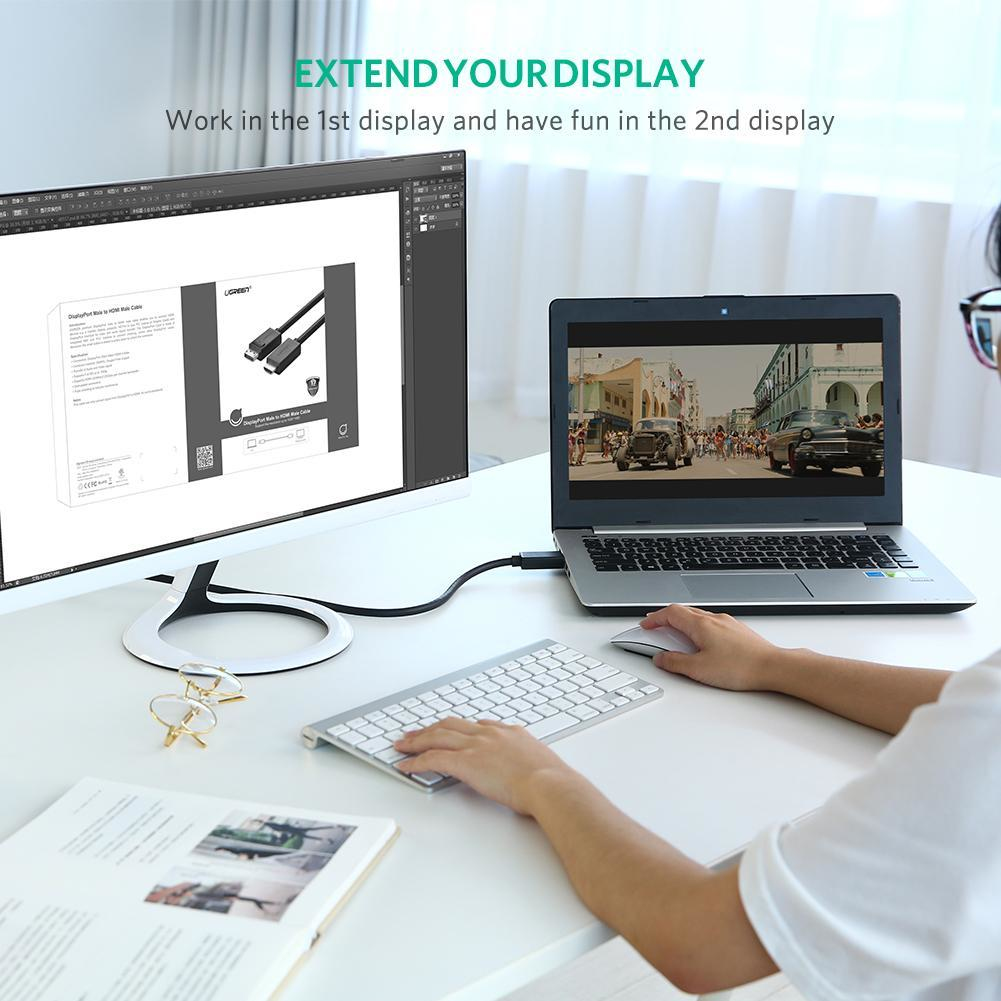 Osoba korzystająca z laptopa podłączonego do monitora. Scena rozgrywa się w środowisku biurowym, z okularami i klawiaturą.