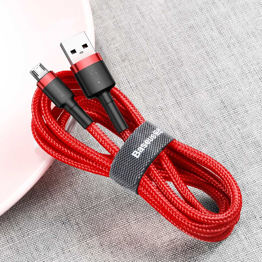 Czerwony kabel USB ze złączami USB-A i micro-USB, owinięty szarym paskiem, na jasnej powierzchni.