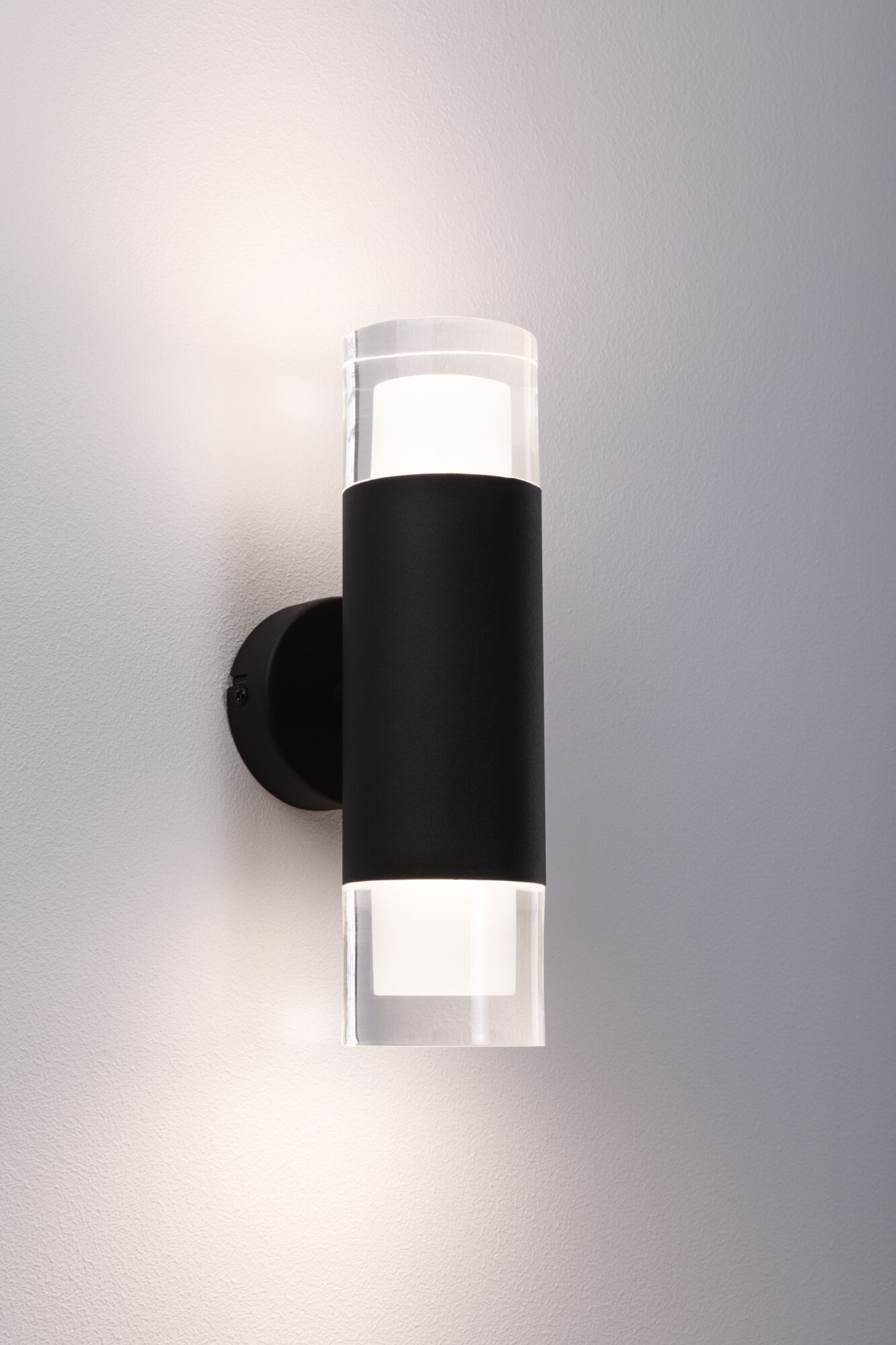 Zylindrische Wandleuchte mit klaren Acrylendstücken und einem schwarzen Körper, die Licht abgibt.