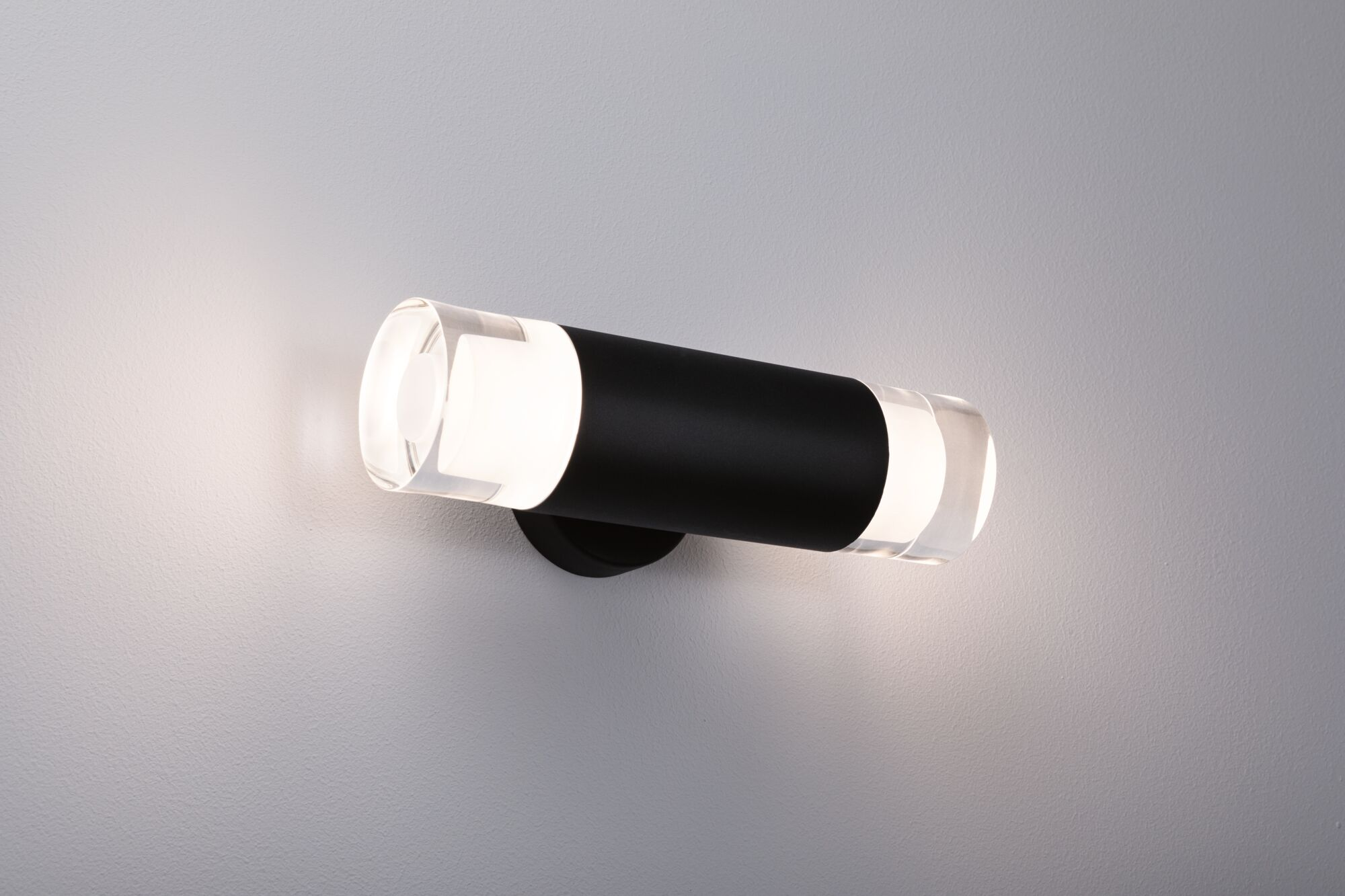 Zylindrische Wandleuchte mit klaren Acrylendstücken und einem schwarzen Körper, die Licht abgibt.