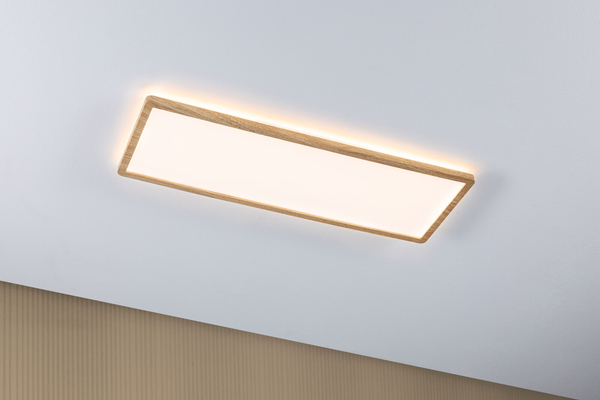 Eine rechteckige LED-Deckenleuchte mit Holzrahmen ist an einer weißen Decke montiert und beleuchtet den Raum.