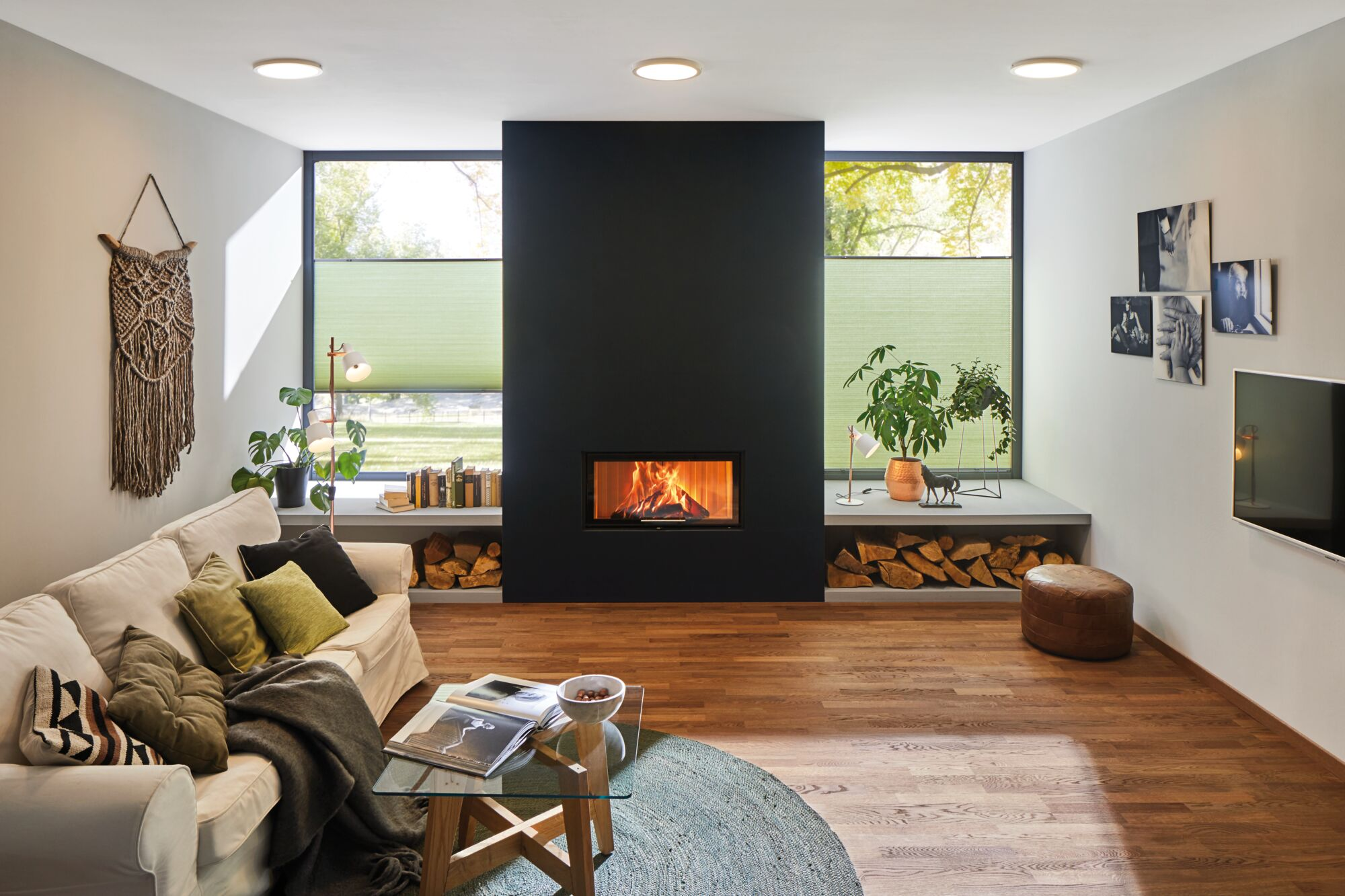 Ein gemütliches Wohnzimmer mit Kamin, Couch, Pflanzen und Dekoration.