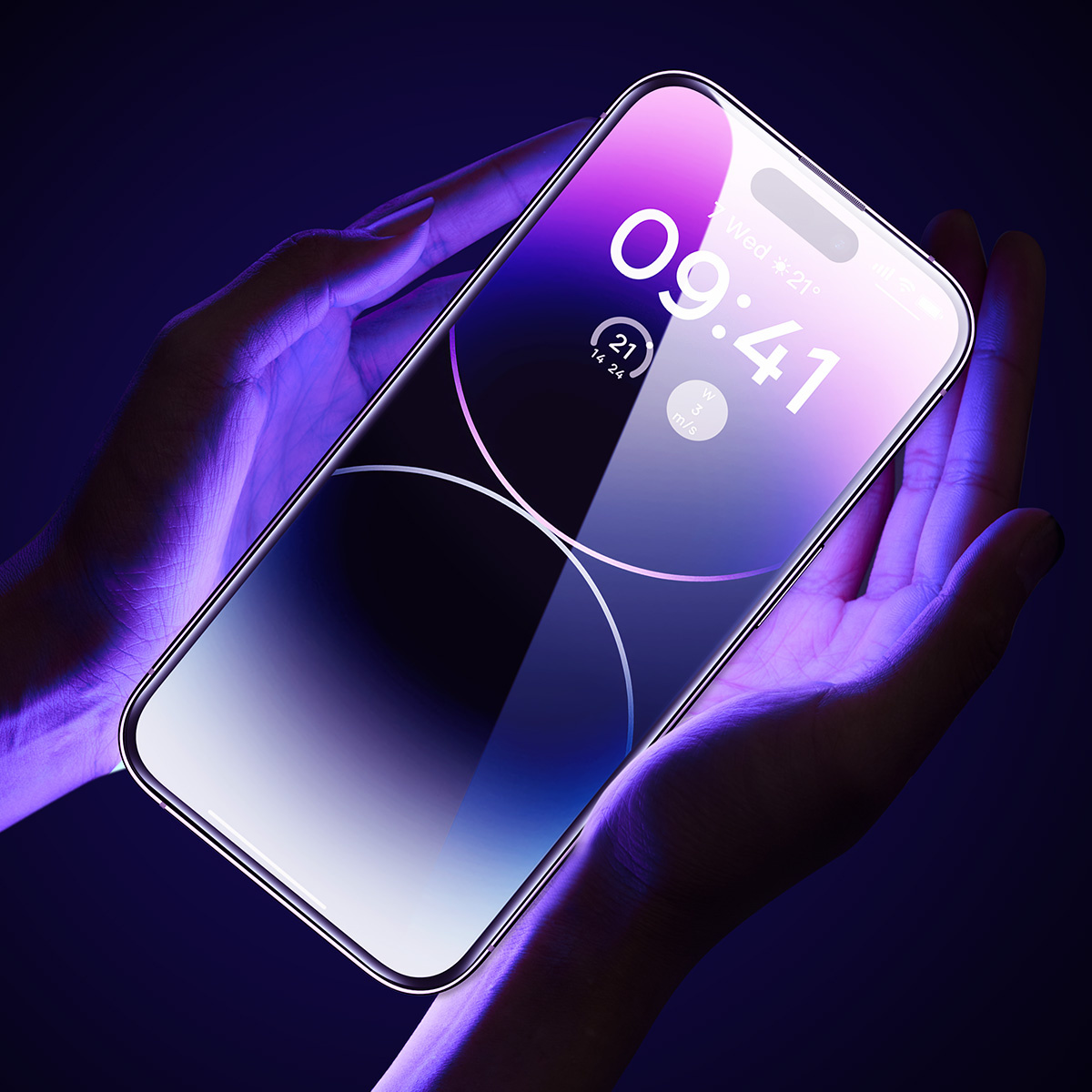 Ręce trzymające smartfon z folią ochronną na ekran, wyświetlający zegar i kolorowy interfejs.