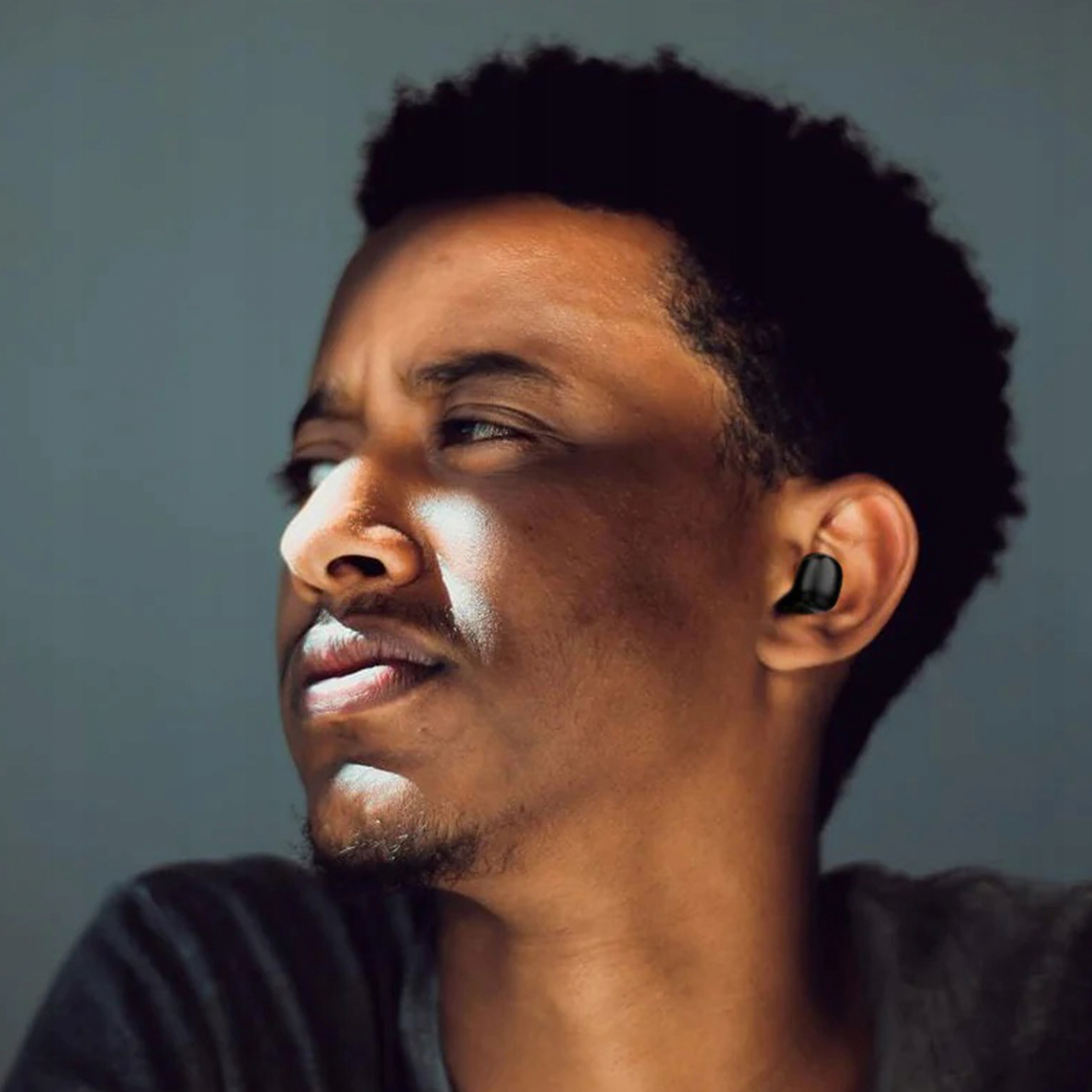 Mężczyzna nosi słuchawkę w lewym uchu.