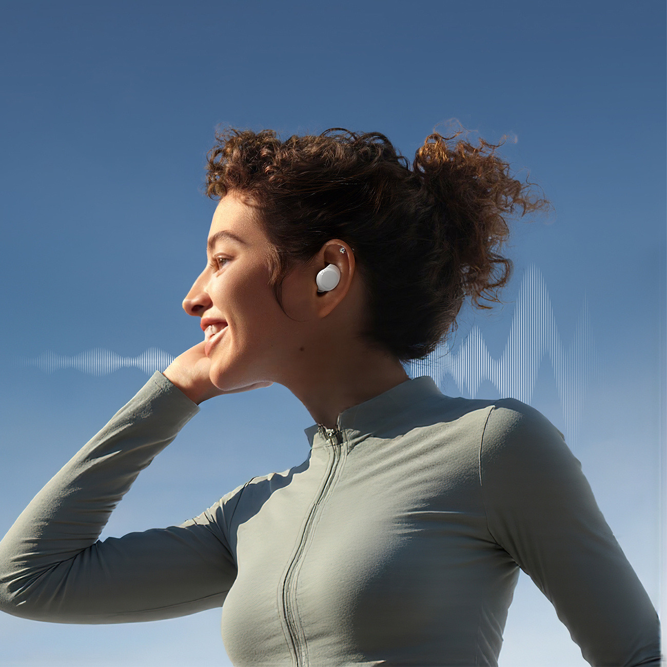 Uśmiechnięta kobieta z kręconymi włosami, nosząca słuchawkę, z grafiką fal dźwiękowych.