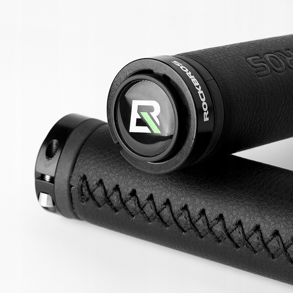 Zbliżenie dwóch czarnych uchwytów kierownicy roweru, jeden z zielonym logo, na białym tle.