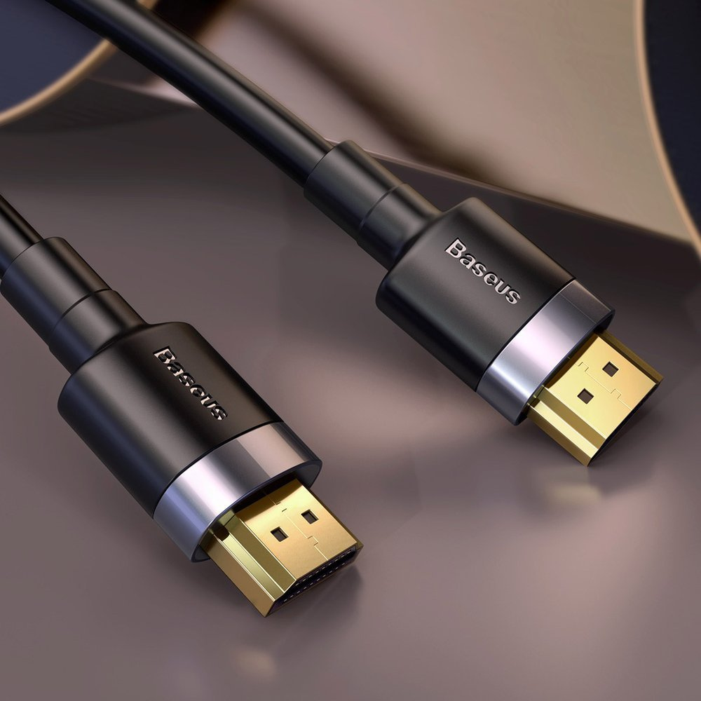 Czarny kabel HDMI Baseus z pozłacanymi złączami pokazany na odblaskowej ciemnej powierzchni, podkreślający jakość i wygląd.