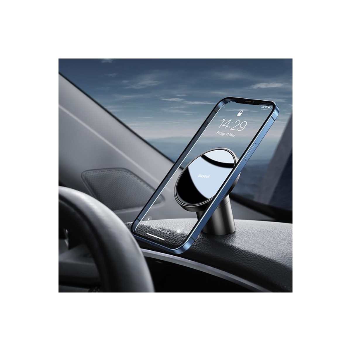 Smartfon przymocowany do magnetycznego uchwytu samochodowego na desce rozdzielczej samochodu, wyświetlający godzinę 14:29.
