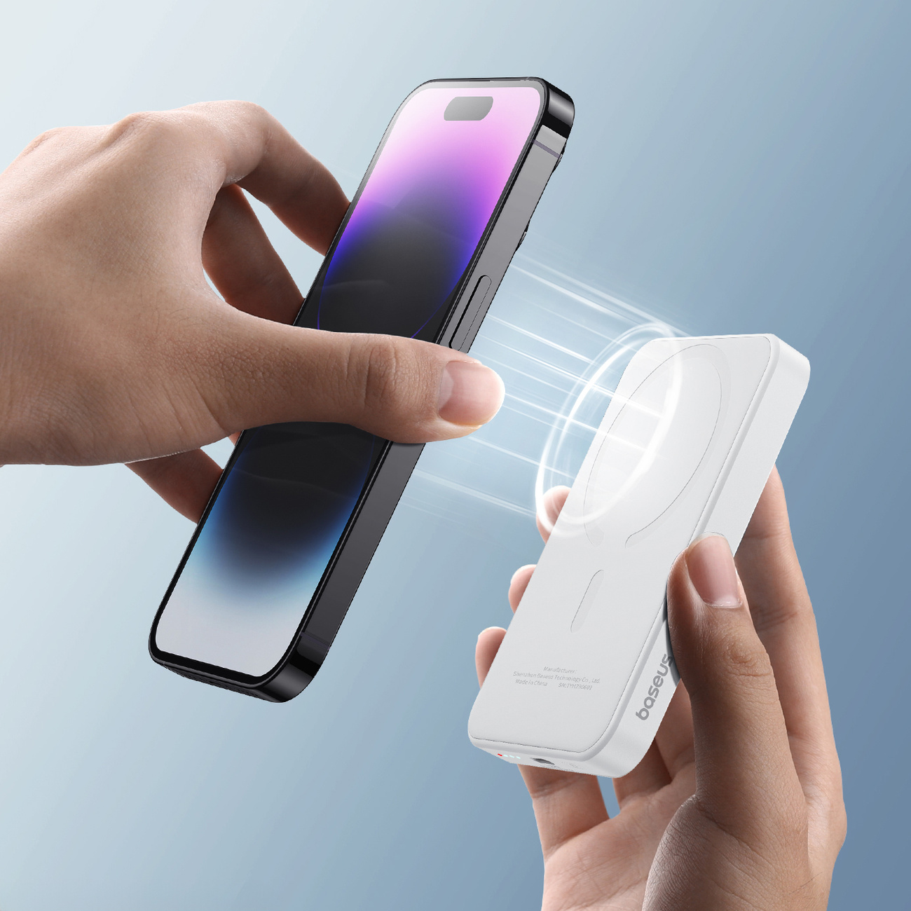 Ręce trzymają telefon i magnetyczny power bank Baseus do ładowania bezprzewodowego.