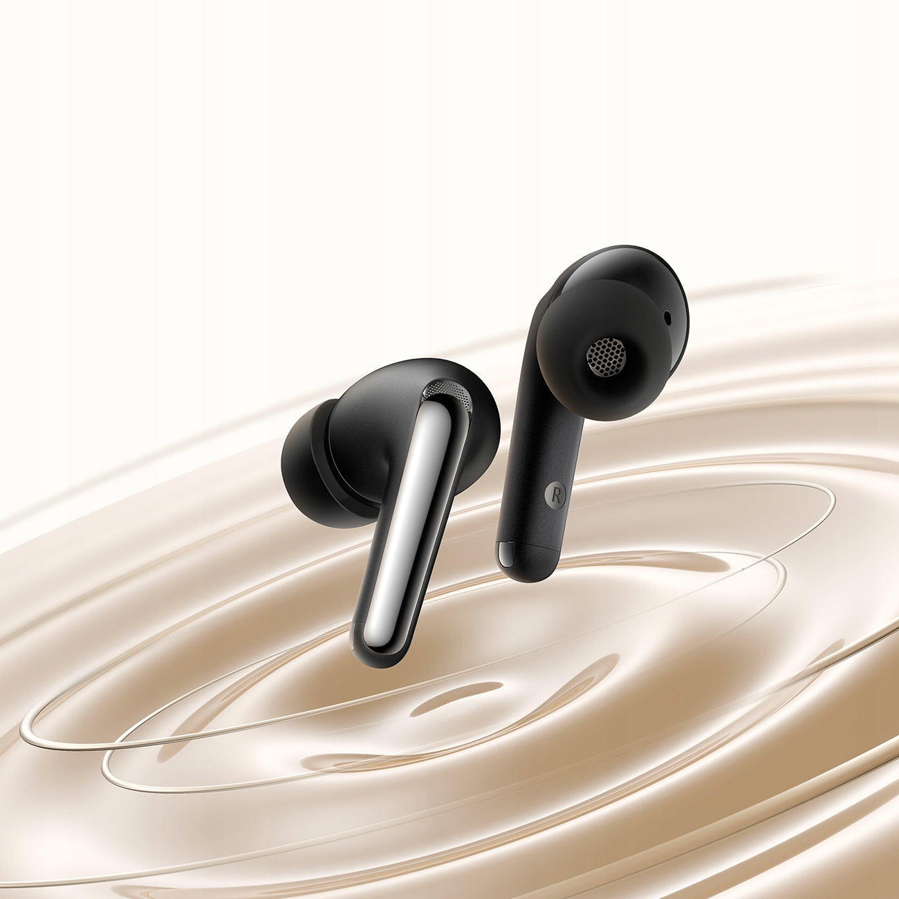 Due auricolari neri. Sono in un astuccio. Lo sfondo è beige con un motivo a onde e un accento metallico.