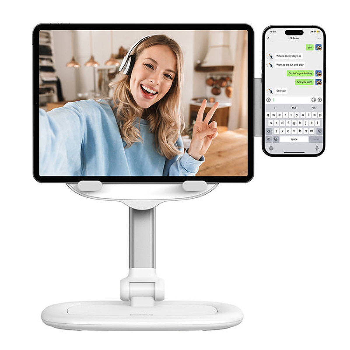 Kobieta prowadzi rozmowę wideo na tablecie trzymanym przez biały stojak. Smartfon wyświetla rozmowę tekstową.
