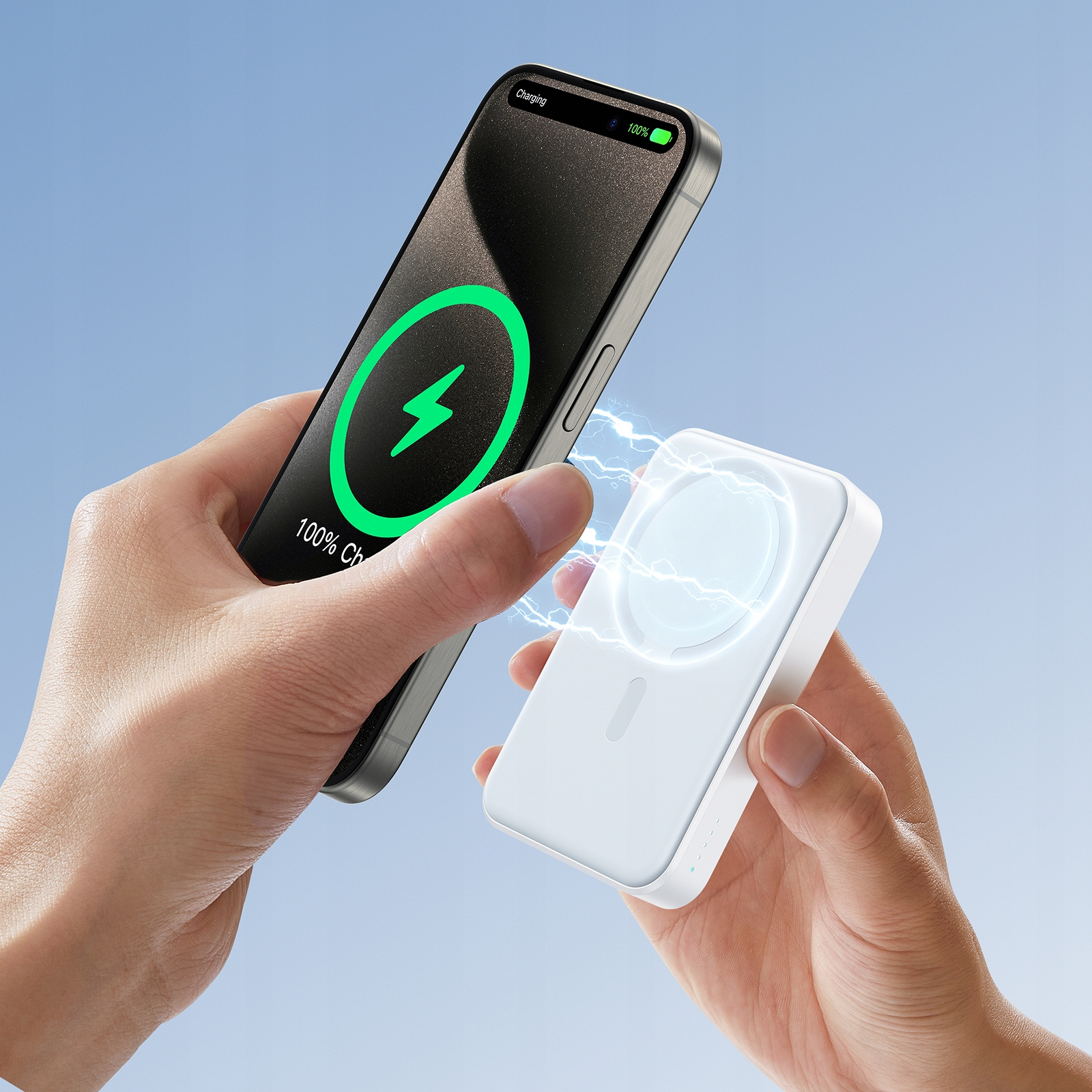 Dłonie trzymające biały power bank ładujący telefon. Ikona błyskawicy pokazuje ładowanie. Tło błękitnego nieba.
