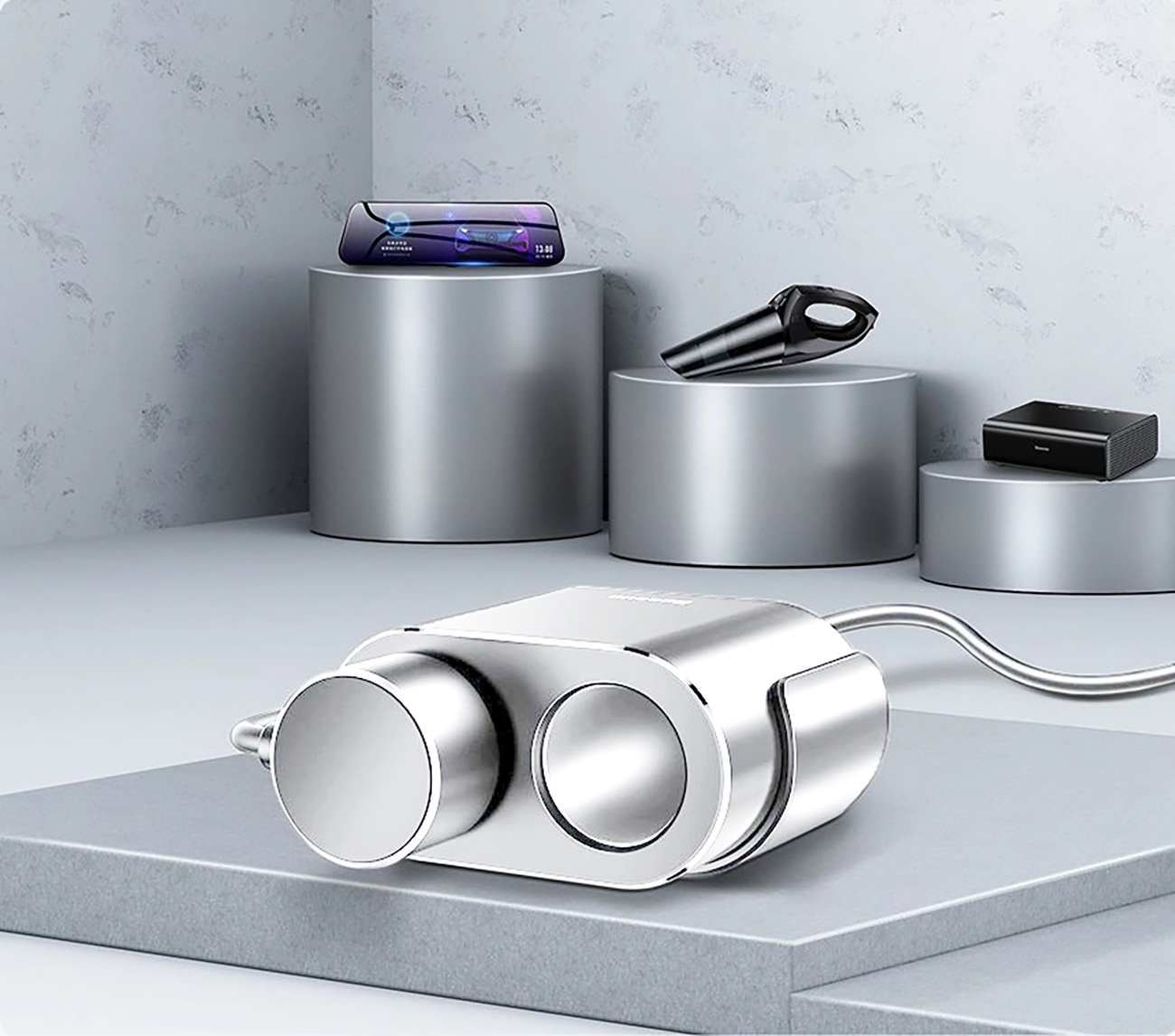 Srebrne urządzenie z dwoma okręgami i innymi przedmiotami na jasnoszarej powierzchni.