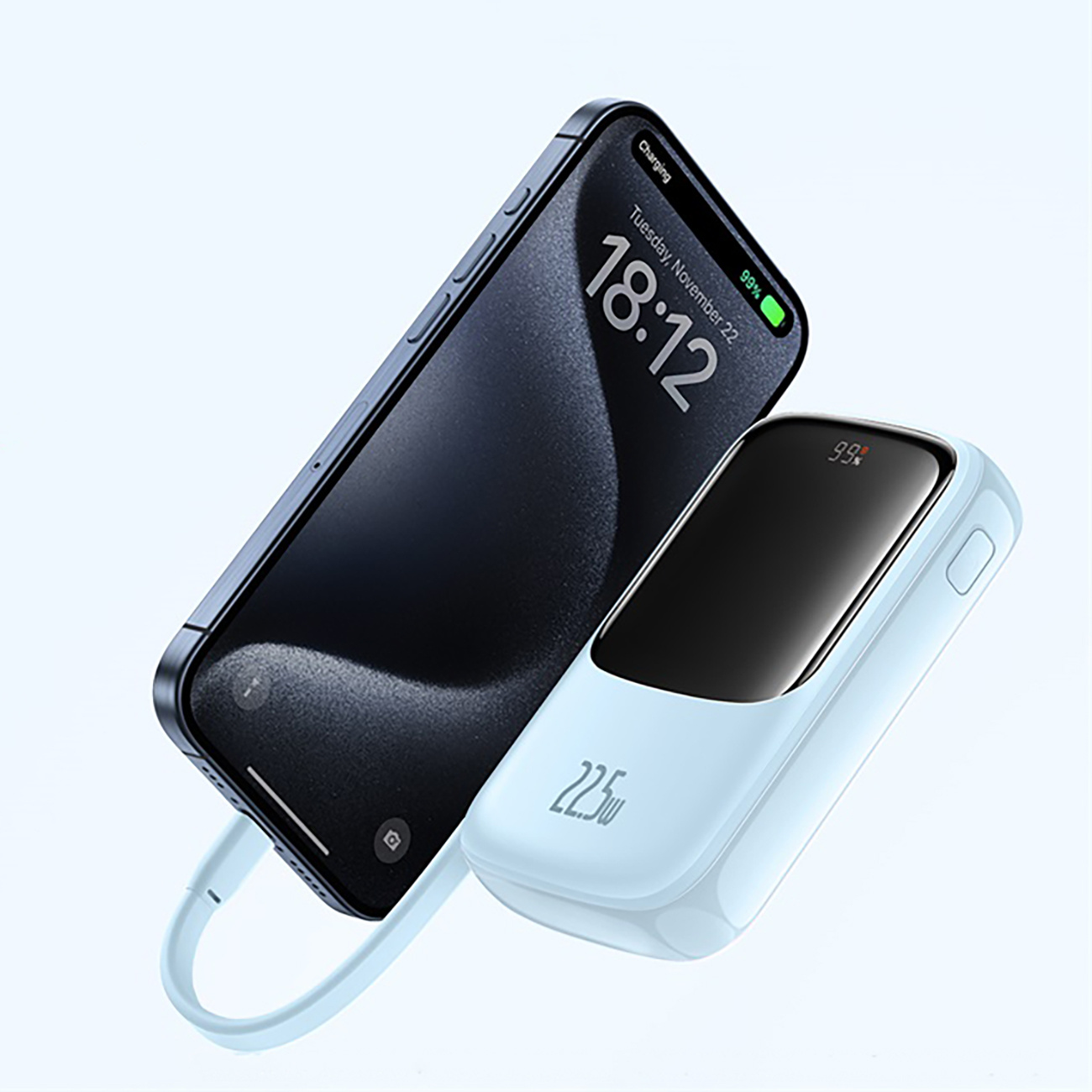 Niebieski telefon komórkowy ładuje się za pomocą jasnoniebieskiego power banku. Ekran telefonu wyświetla godzinę 18:12, 22 listopada i 99%.