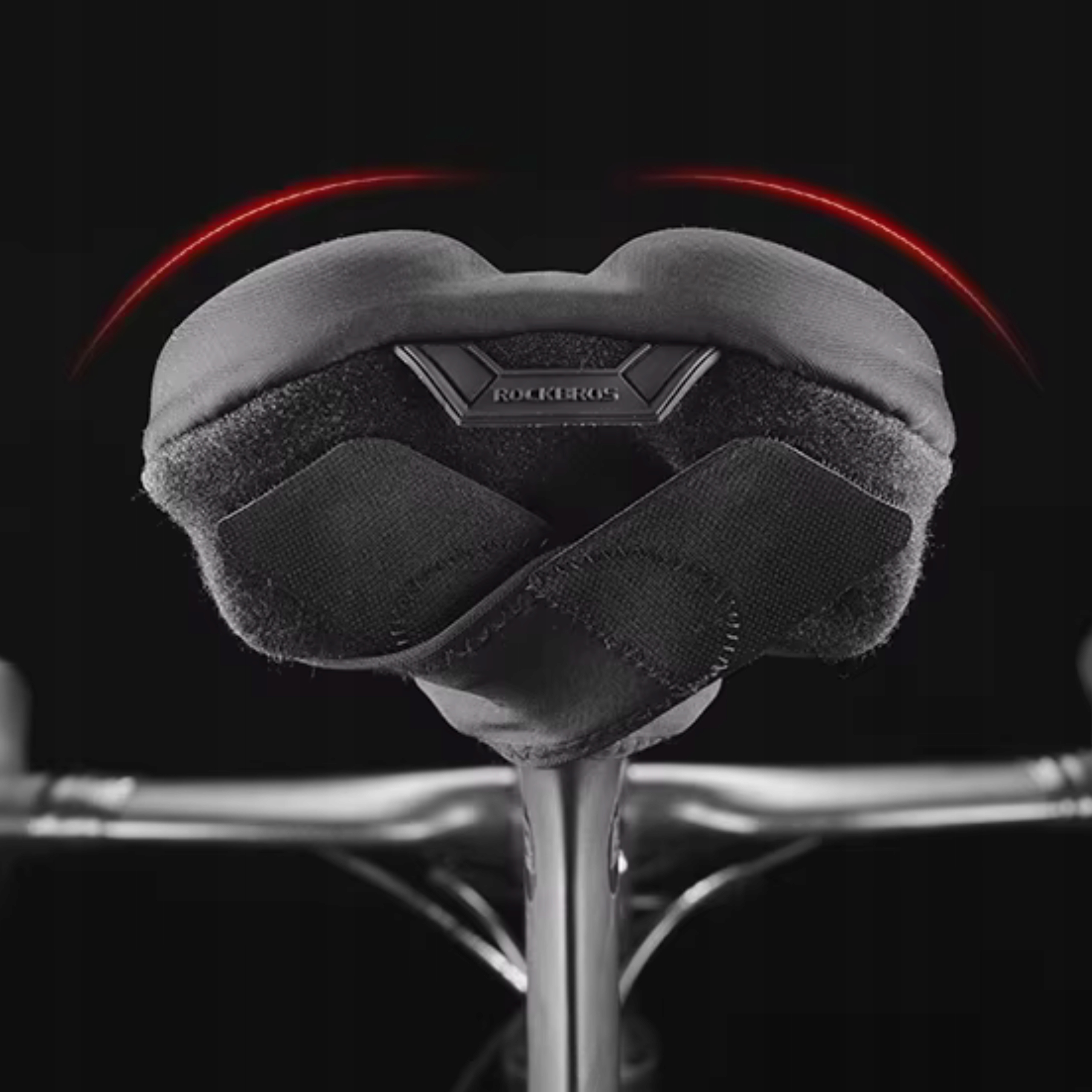 Czarny pokrowiec na siedzenie rowerowe z marką ROCKBROS jest zamontowany na rowerze na ciemnym tle.