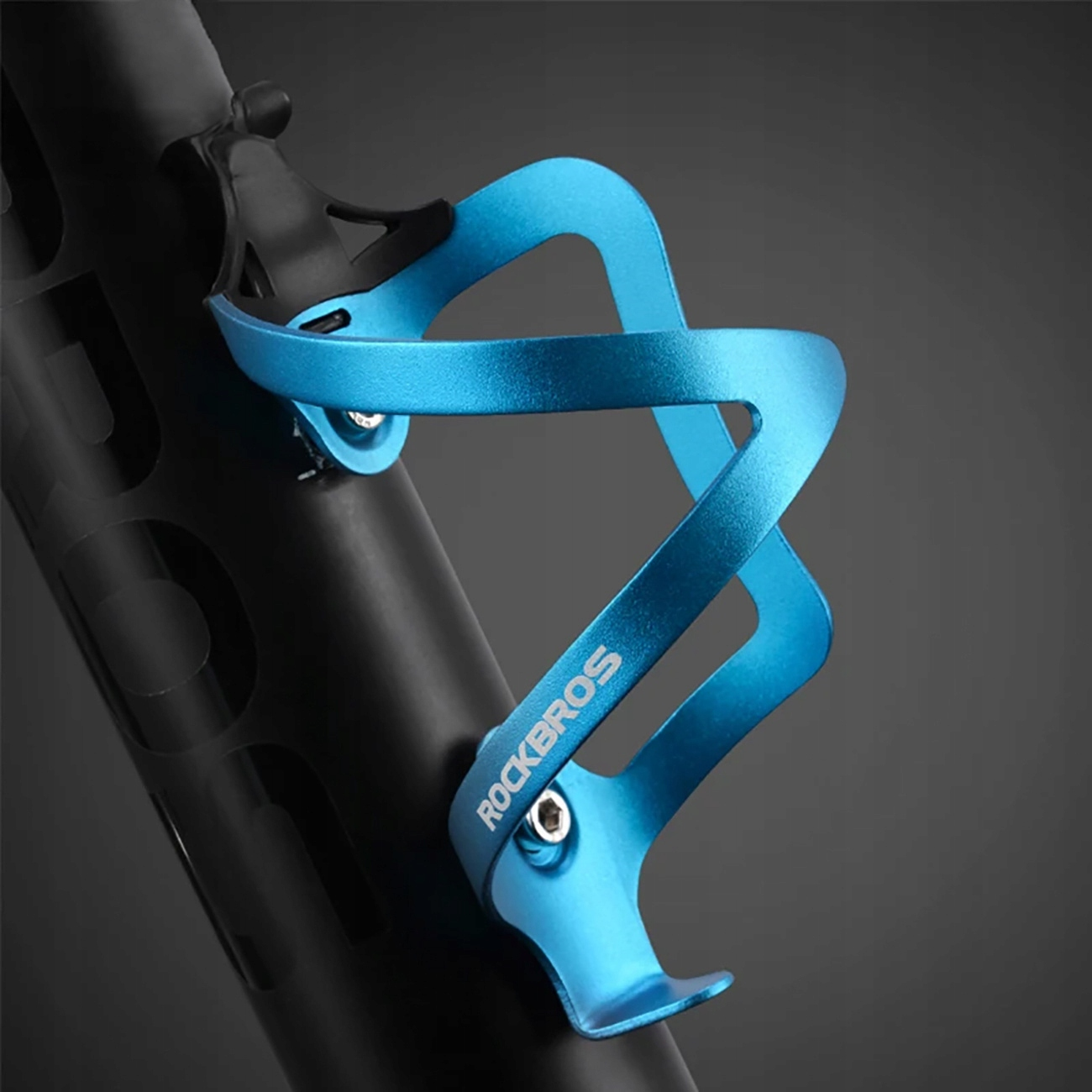 Niebieski koszyk na bidon ROCKBROS jest zamontowany na czarnej ramie roweru, z bliska.