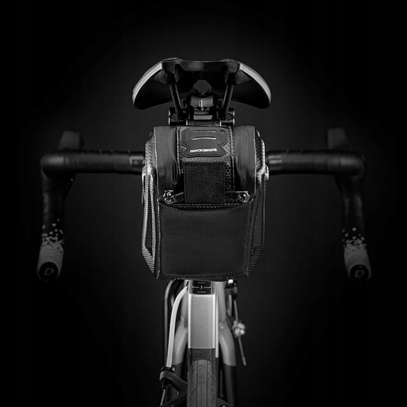 Czarna torba ROCKBROS przymocowana do kierownicy i siedzenia roweru, na ciemnym tle.