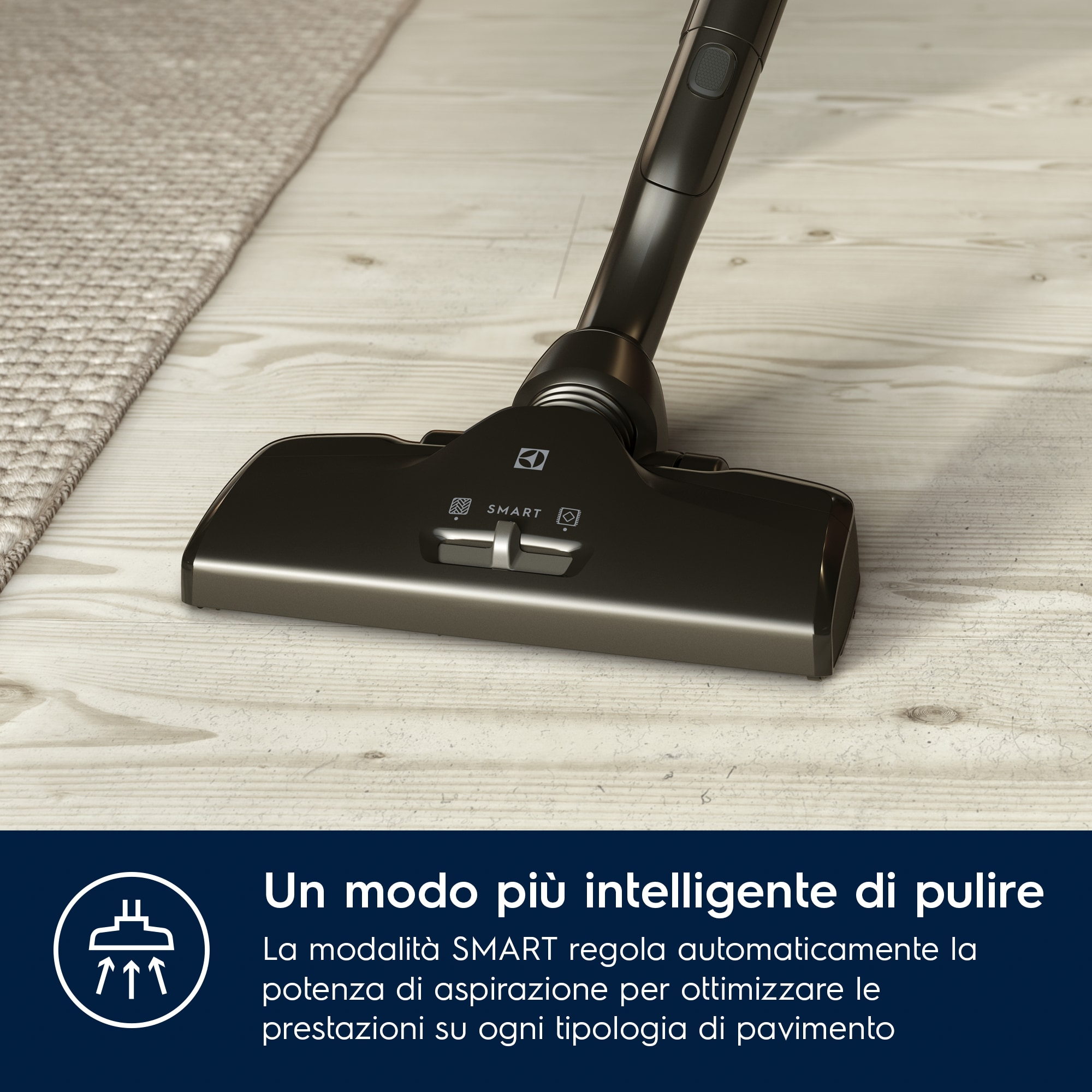 Una testina di aspirapolvere nera su un pavimento in legno chiaro. Testo in italiano presente.