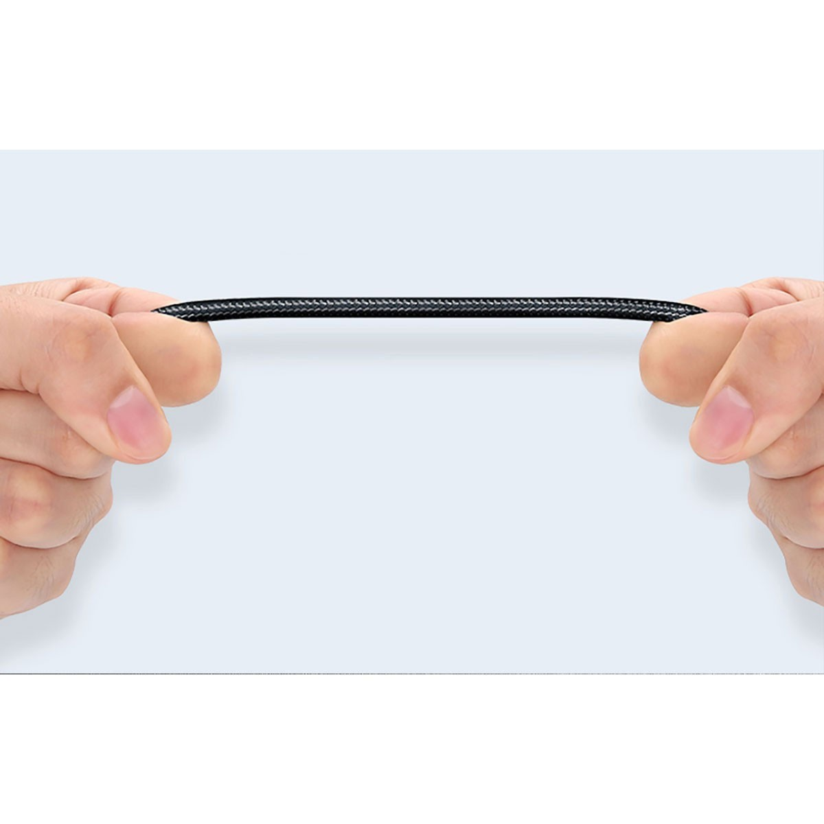 Dwie ręce rozciągają czarny kabel audio na jasnoniebieskim tle.