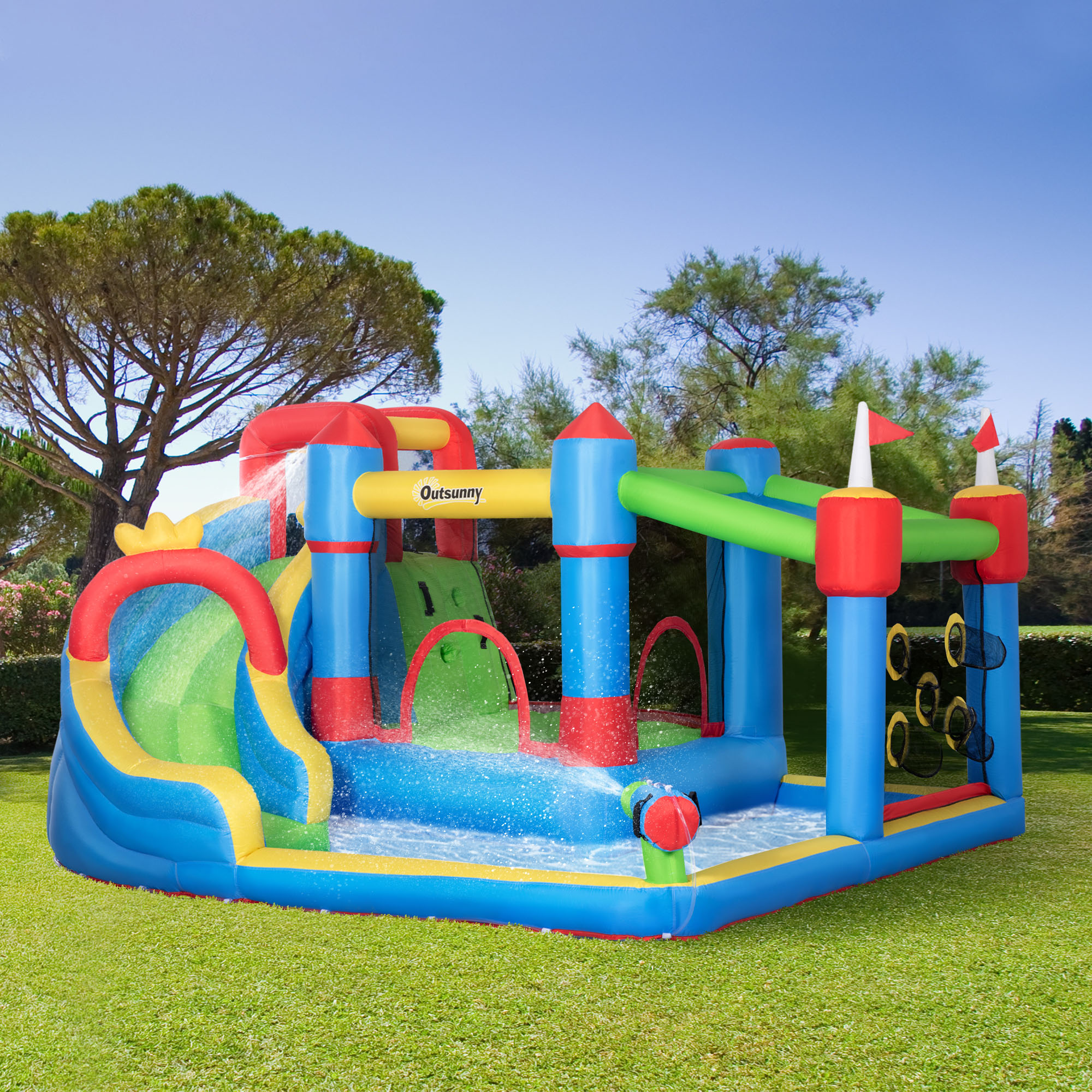 Casa de rebote inflable con tobogán, pared de escalada y características de agua, ubicada al aire libre sobre césped.