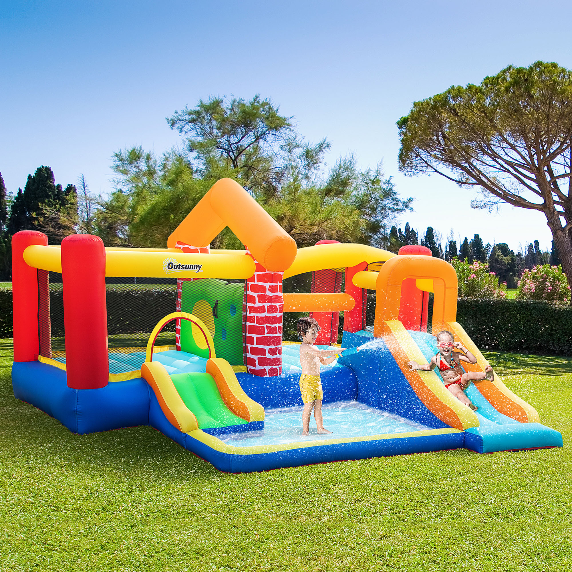 Un colorido parque acuático inflable con niños jugando en un jardín.