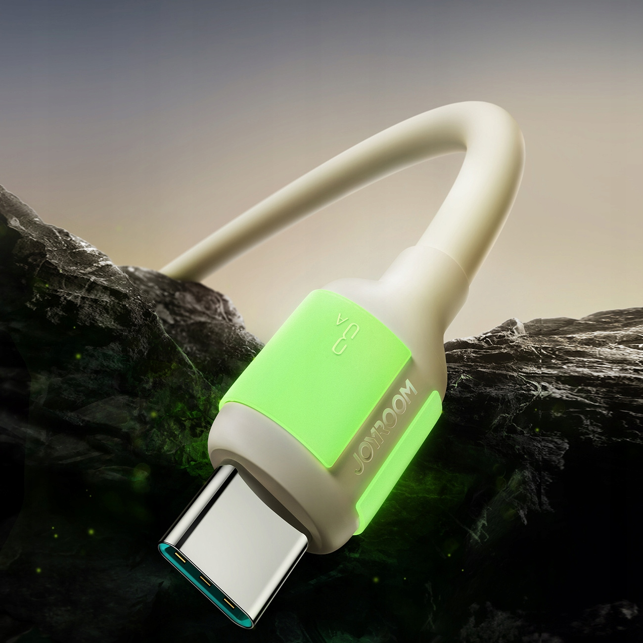 Eine Nahaufnahme zeigt ein weißes USB-C-Kabel mit einem leuchtend grünen Akzent, das auf einer dunklen, felsigen Oberfläche liegt.