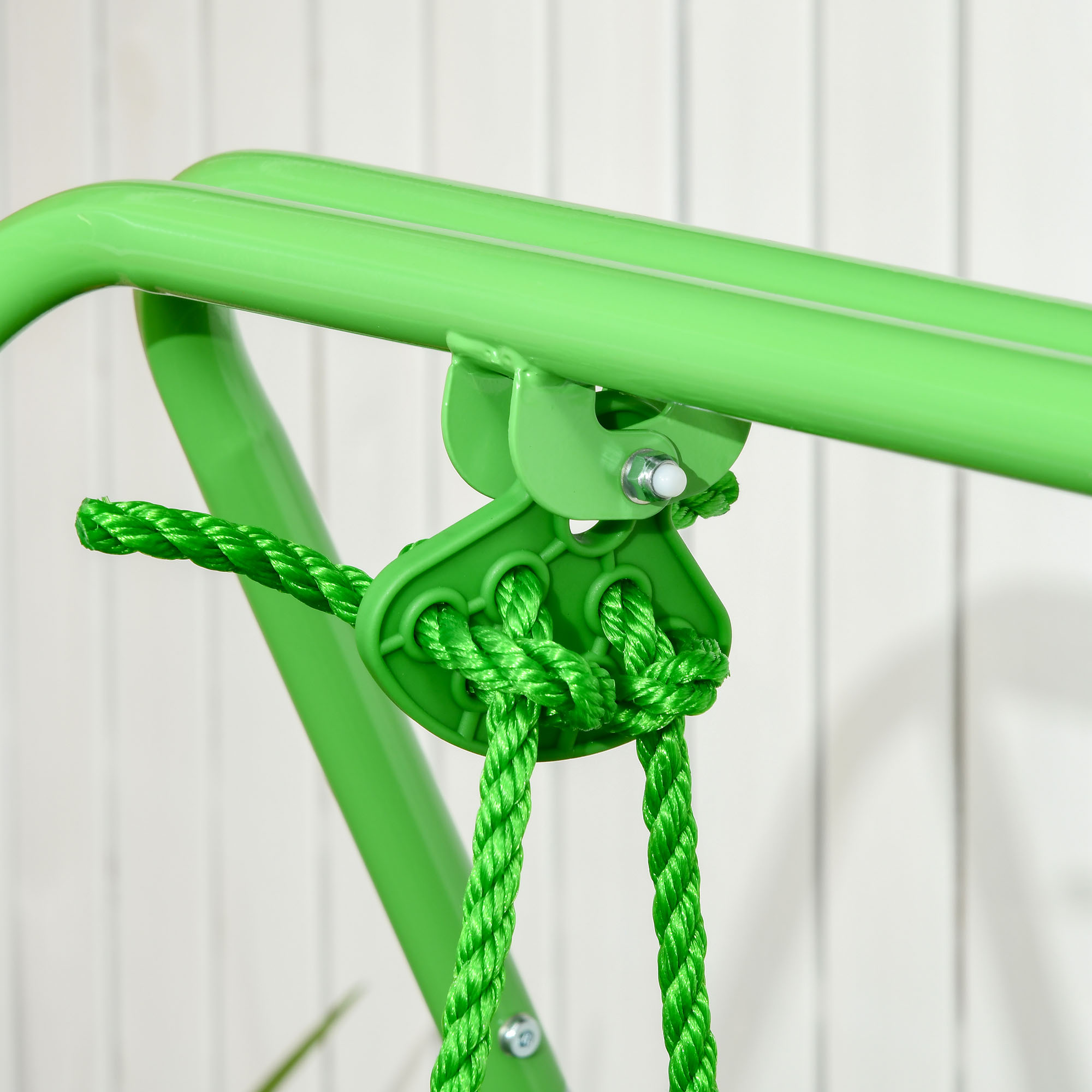 Primer plano de un columpio verde con cuerdas y un marco de metal.