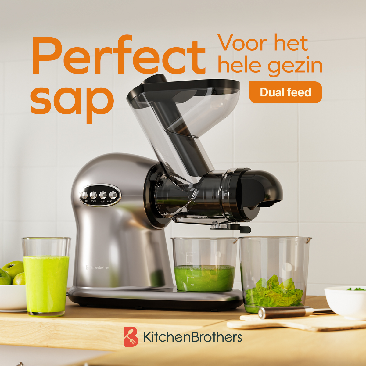 Een zilveren KitchenBrothers juicer met tekstoverlay, fruit en groenten eromheen.