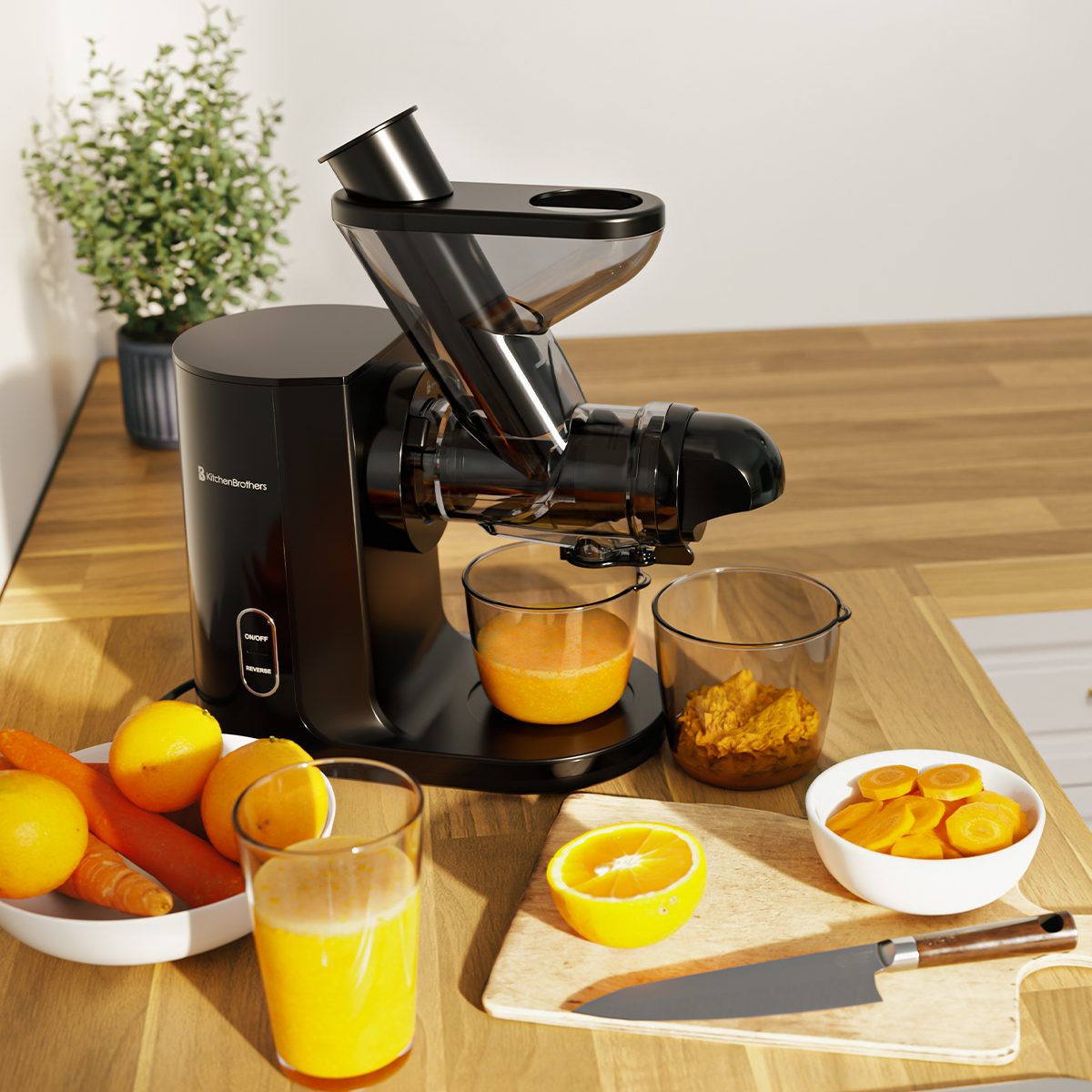 A black juicer is on a wood counter with cut oranges, carrots, and juice.