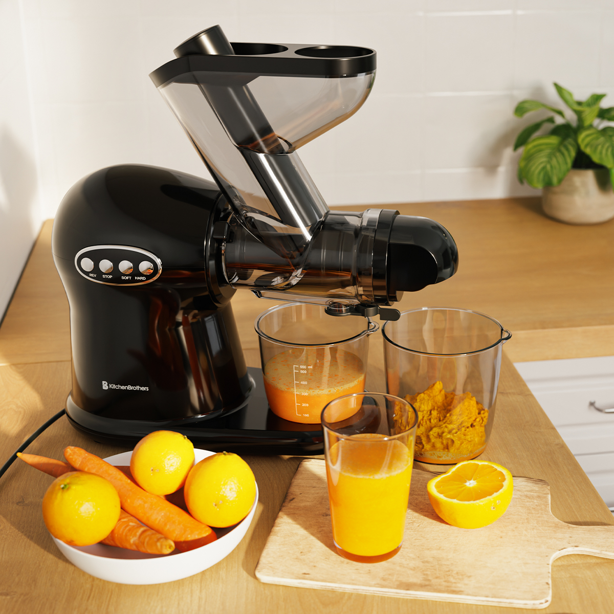 Zwarte KitchenBrothers slowjuicer die sinaasappelsap perst naast citroenen en wortelen.