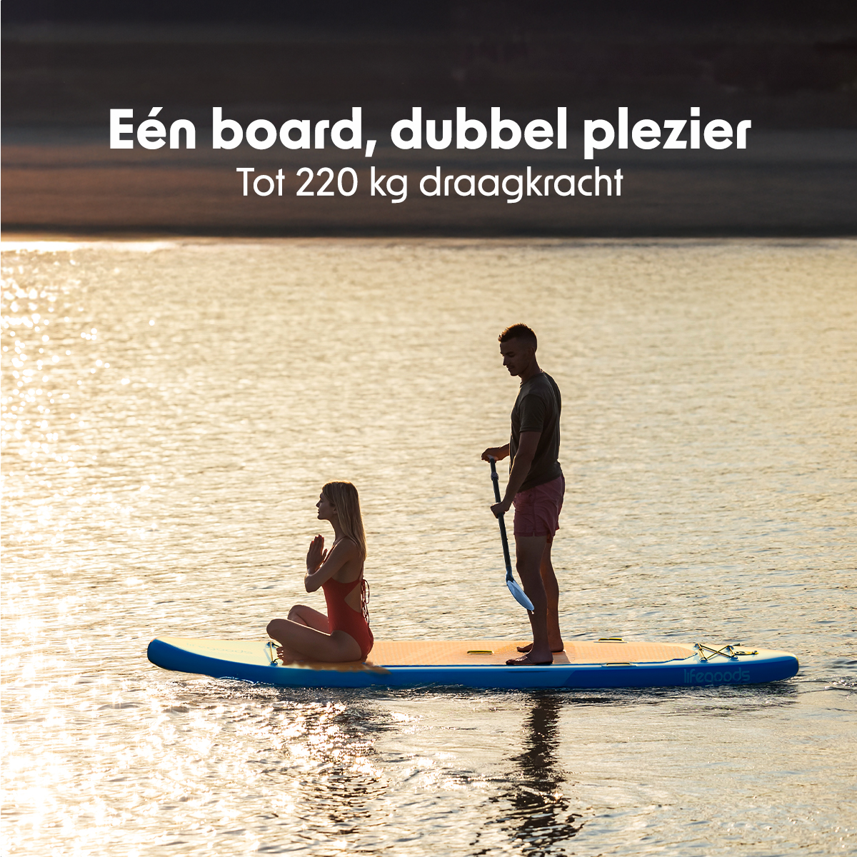 Ein Mann und eine Frau paddeln bei Sonnenuntergang auf einem See. Der Text wirbt für das Tandem-Board.