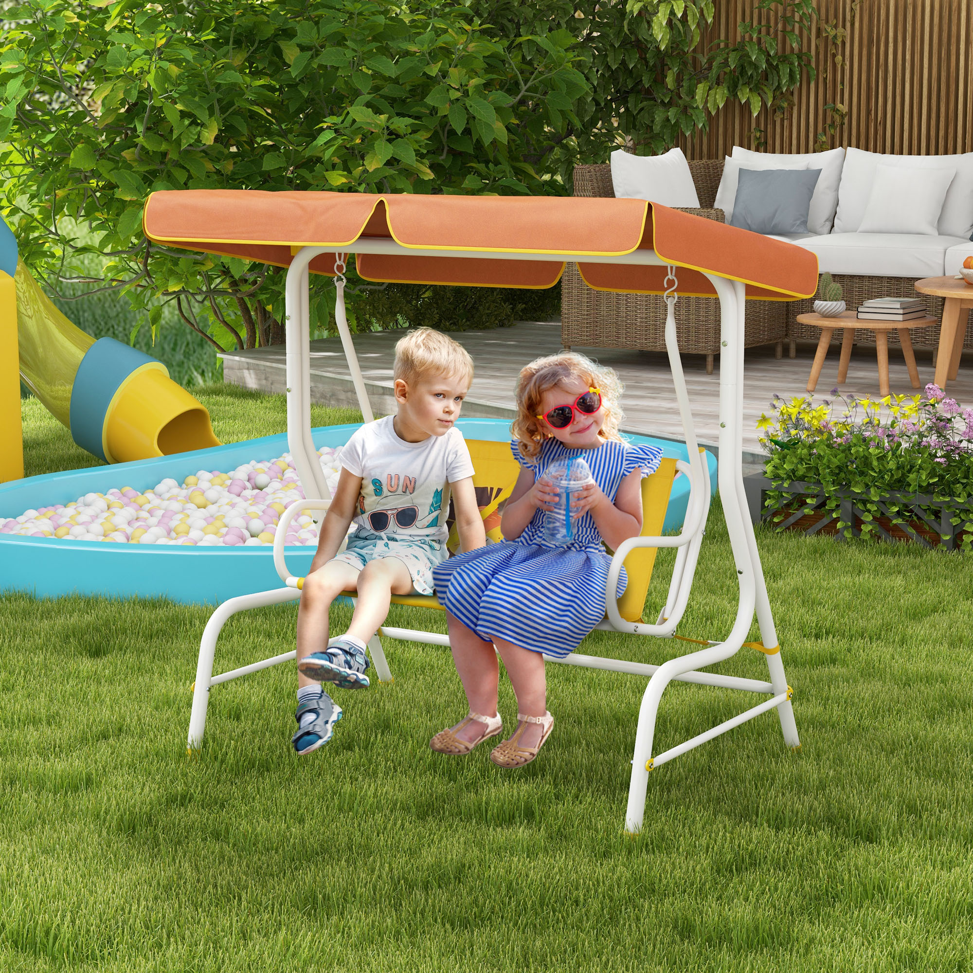 Niños en un columpio blanco con un toldo naranja en un patio trasero.